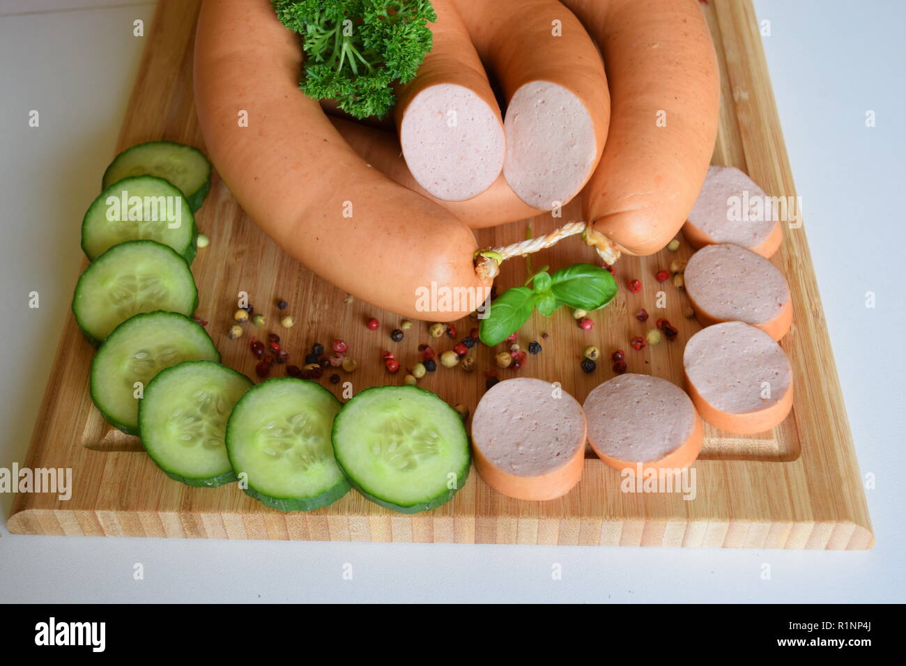 Lyoner is a Sausage delicatessen on a wooden rustic plate.          Lyoner ist eine Wurstspezialität auf einer rustikalen Holzplatte. Stock Photo