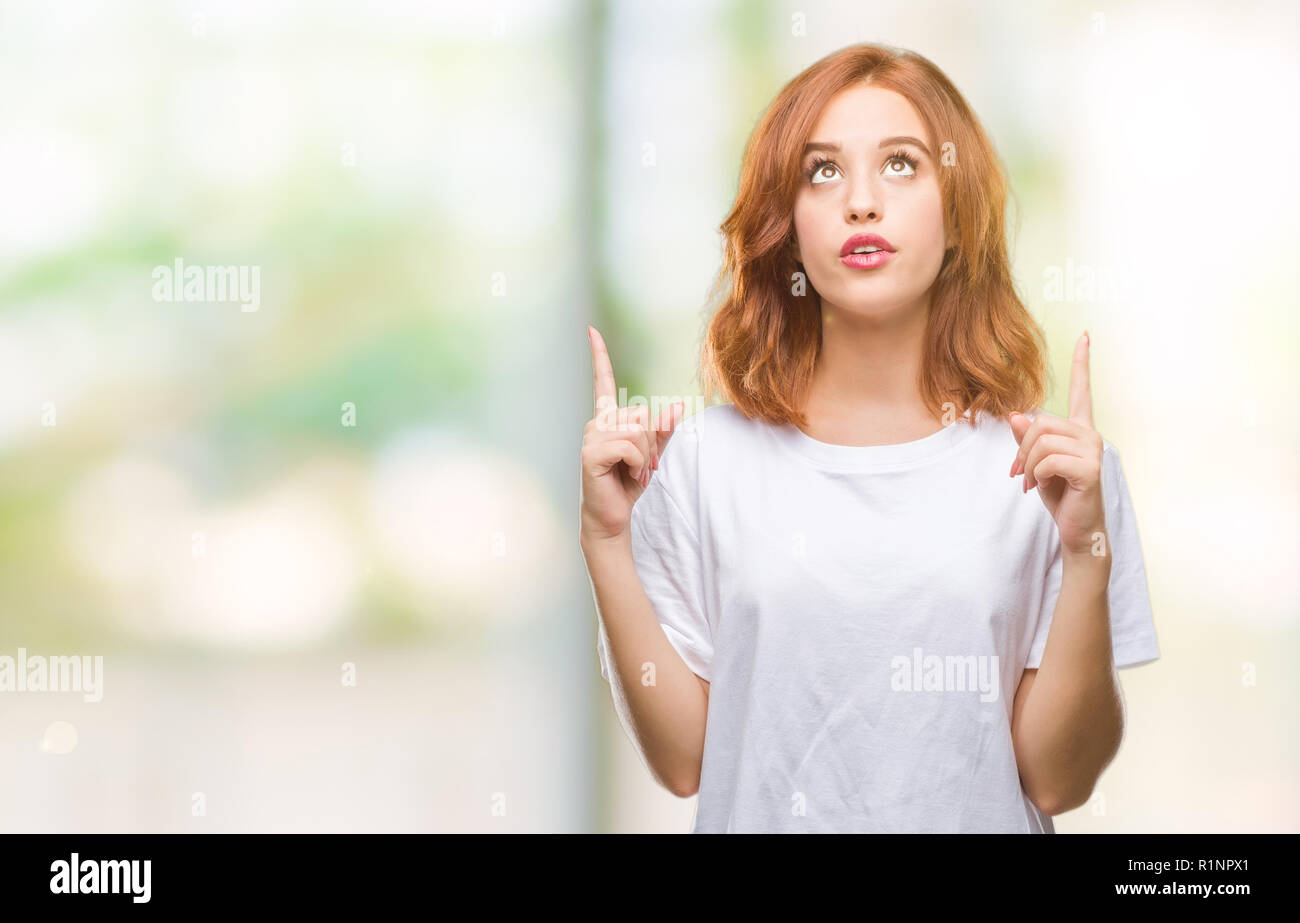 Young beautiful woman over isolated background amazed and surprised ...