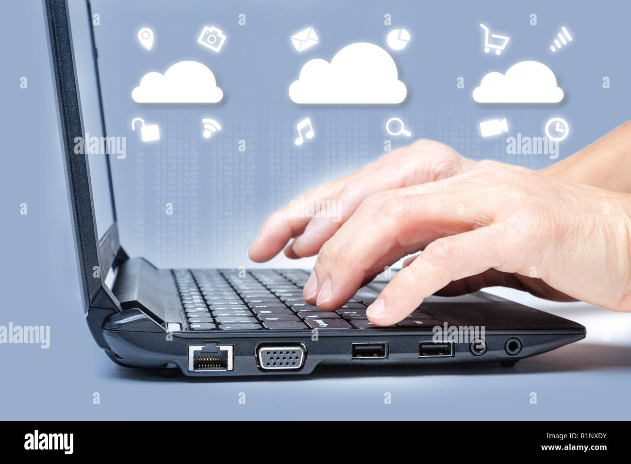 Cloud computing concept showing hands typing on computer keyboard with common Internet media icons around clouds from digital data. Stock Photo