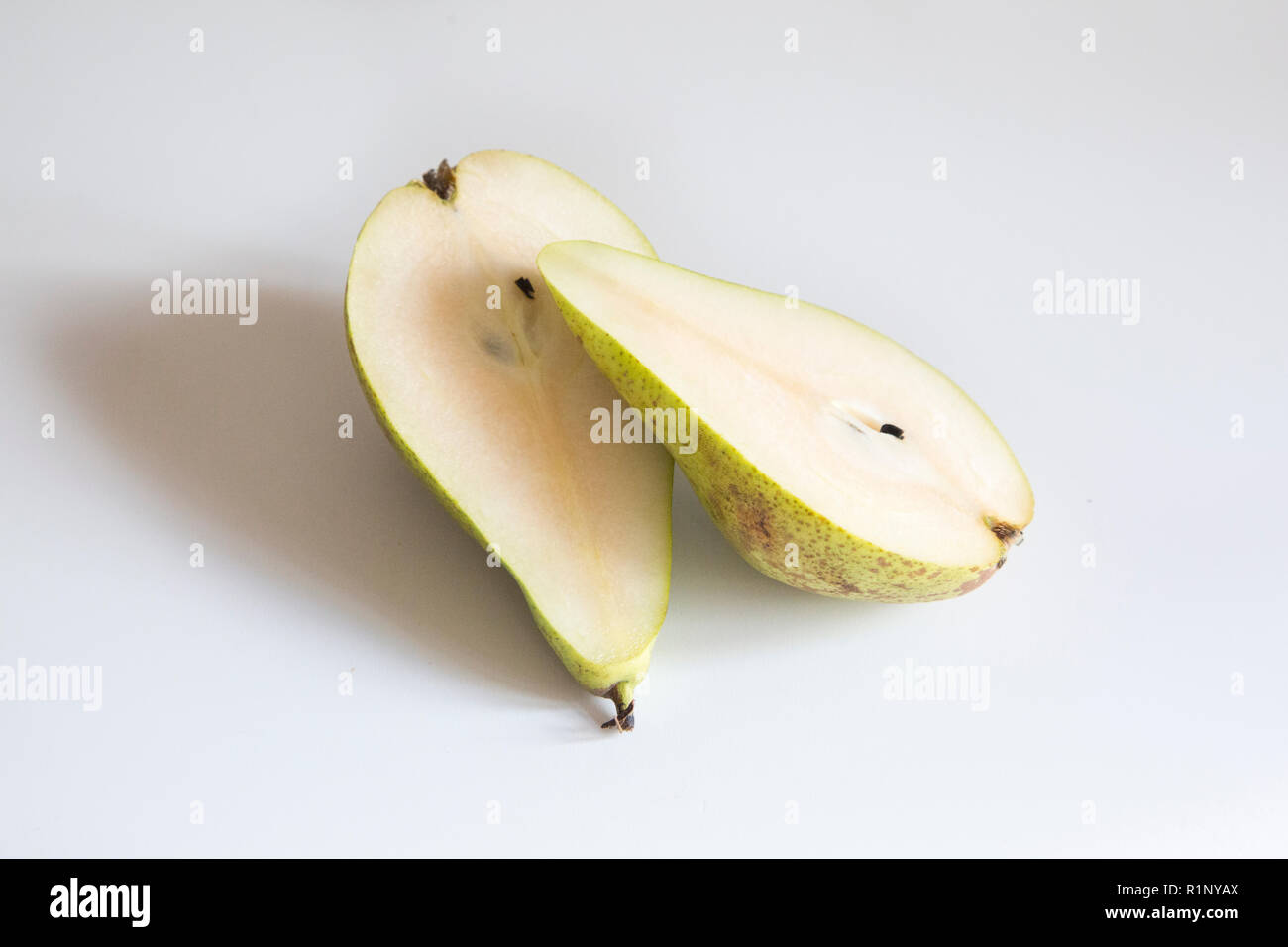 Pear cut in half length ways on a white background Stock Photo