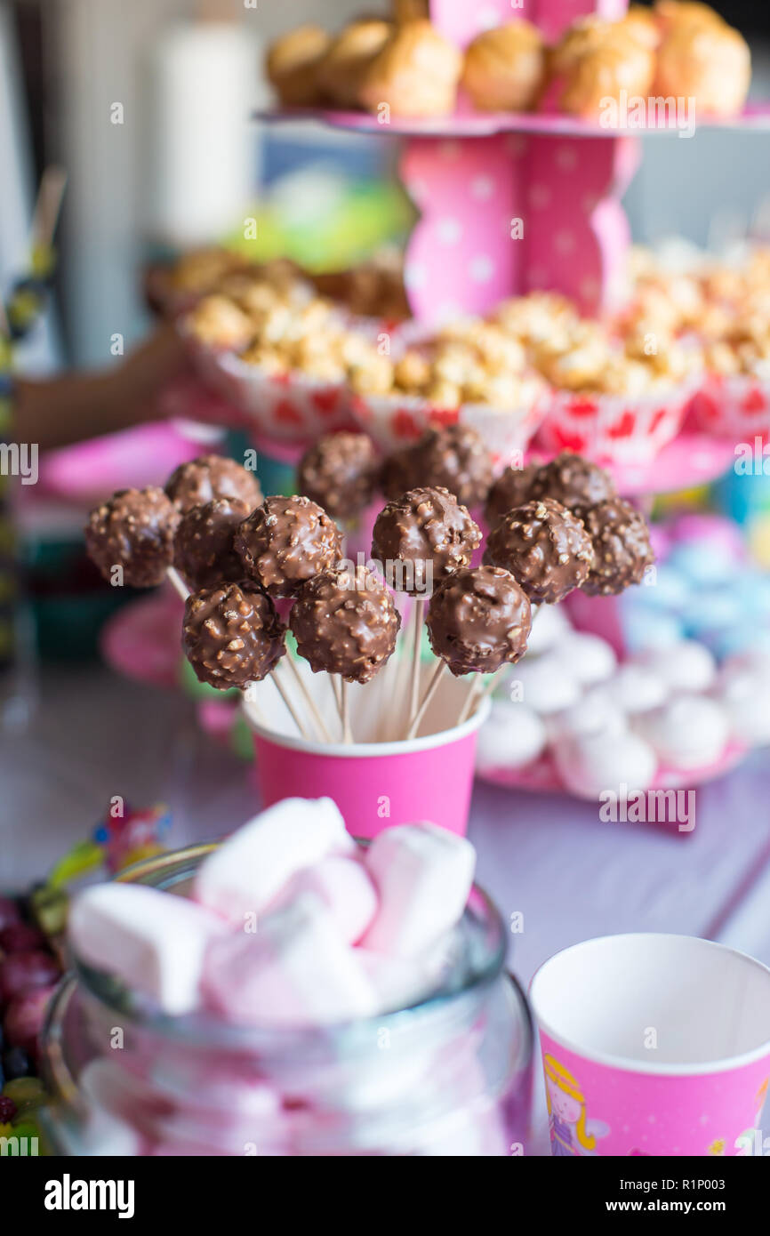 Chocolate cakepops and popcorn on dessert table at kid birthday party
