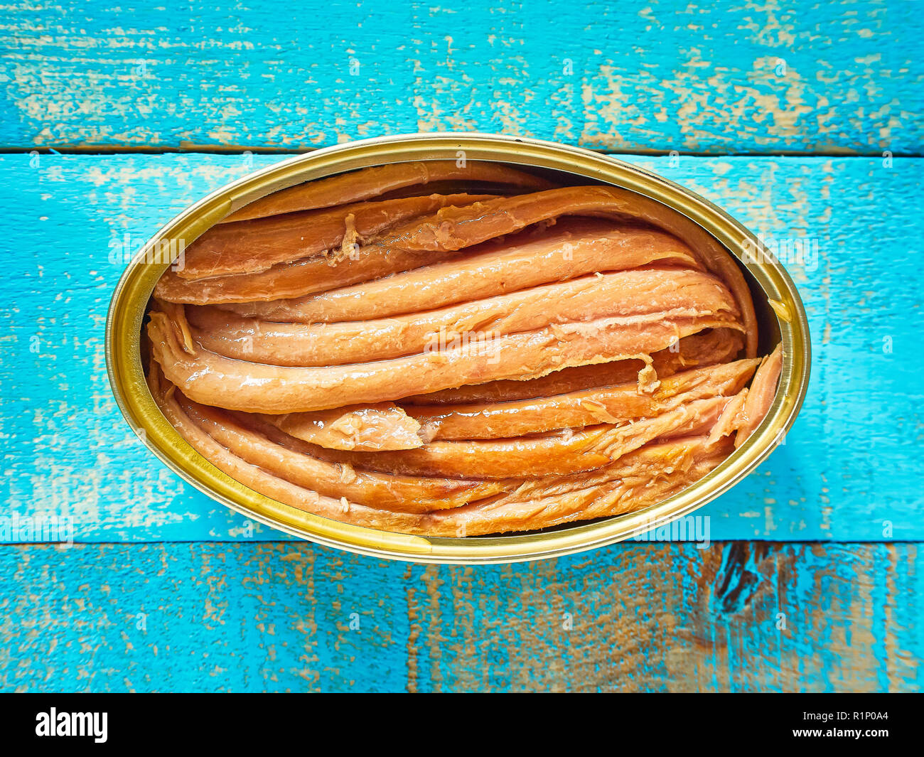 Can of Tuna in Oil. Canned Tuna fish over a Mediterranean blue wooden
