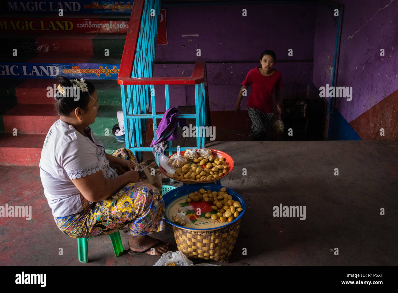 Woman walking up a staircase in the Magic Land Market, Mandalay, Myanmar. Stock Photo