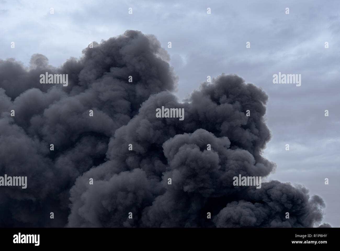 Forms and shapes in a cloud of toxic pollution smoke from a factory fire against a cloudy blue