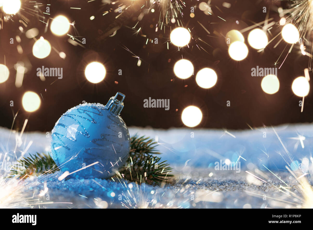 Christmas ball with sparklers and garlands on the snow Stock Photo