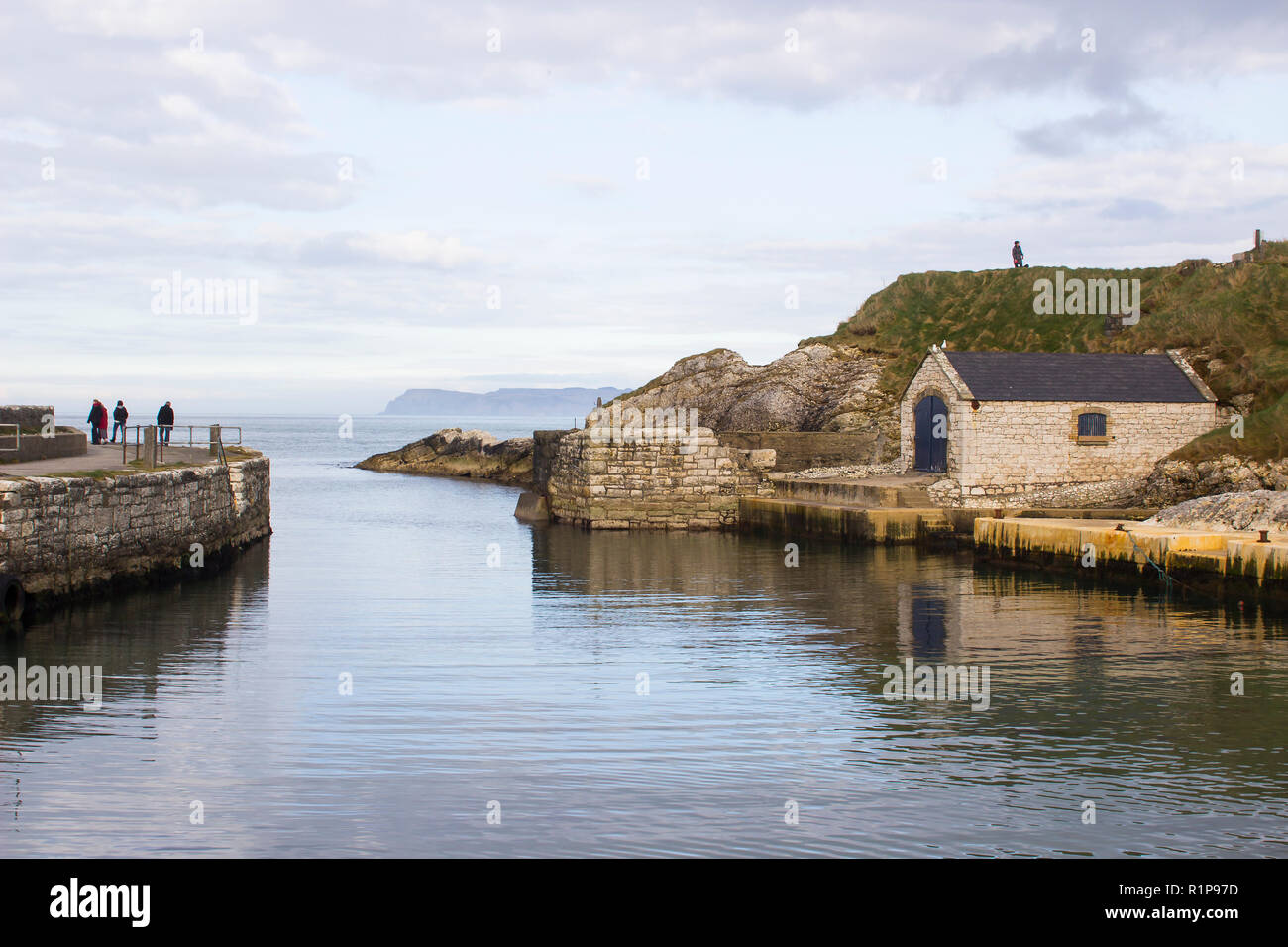 The small harbor at Ballintoy on the North Antrim Coast of Northern Ireland with its ancient stone built boathouse on a day in spring Stock Photo