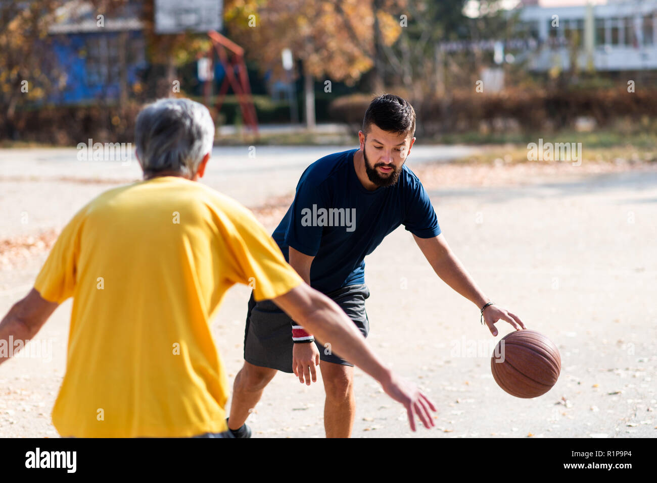 Father and son playing basketball in the park Stock Photo