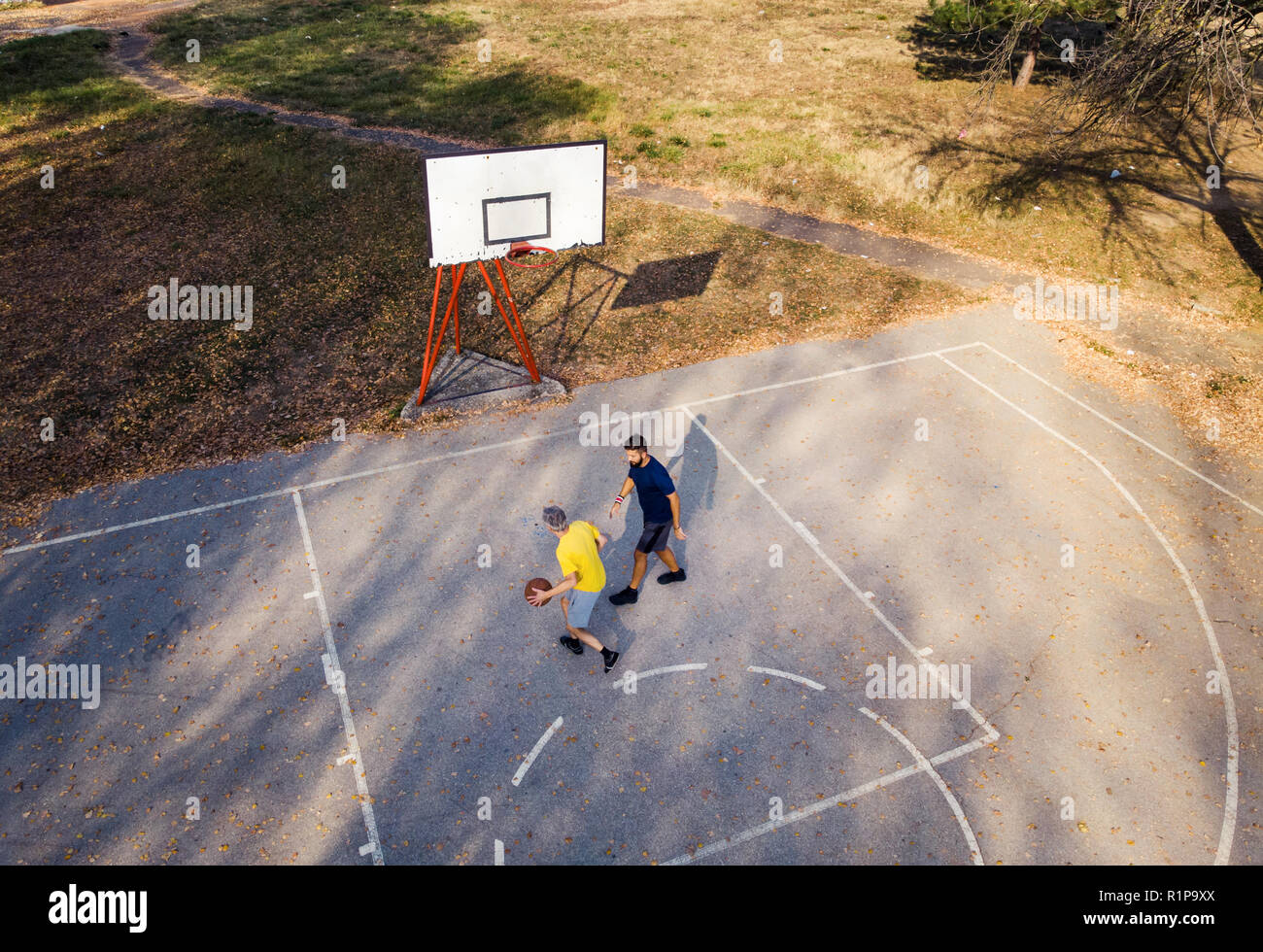 Father and son playing basketball in the park aerial view Stock Photo