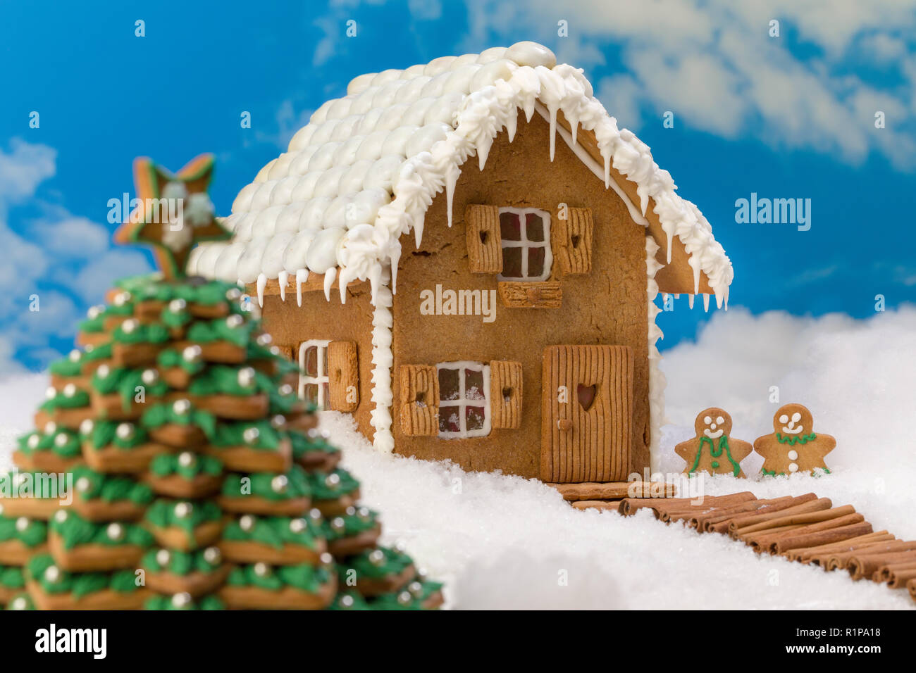 Cookie christmas tree and gingerbread house in a snow landscape Stock