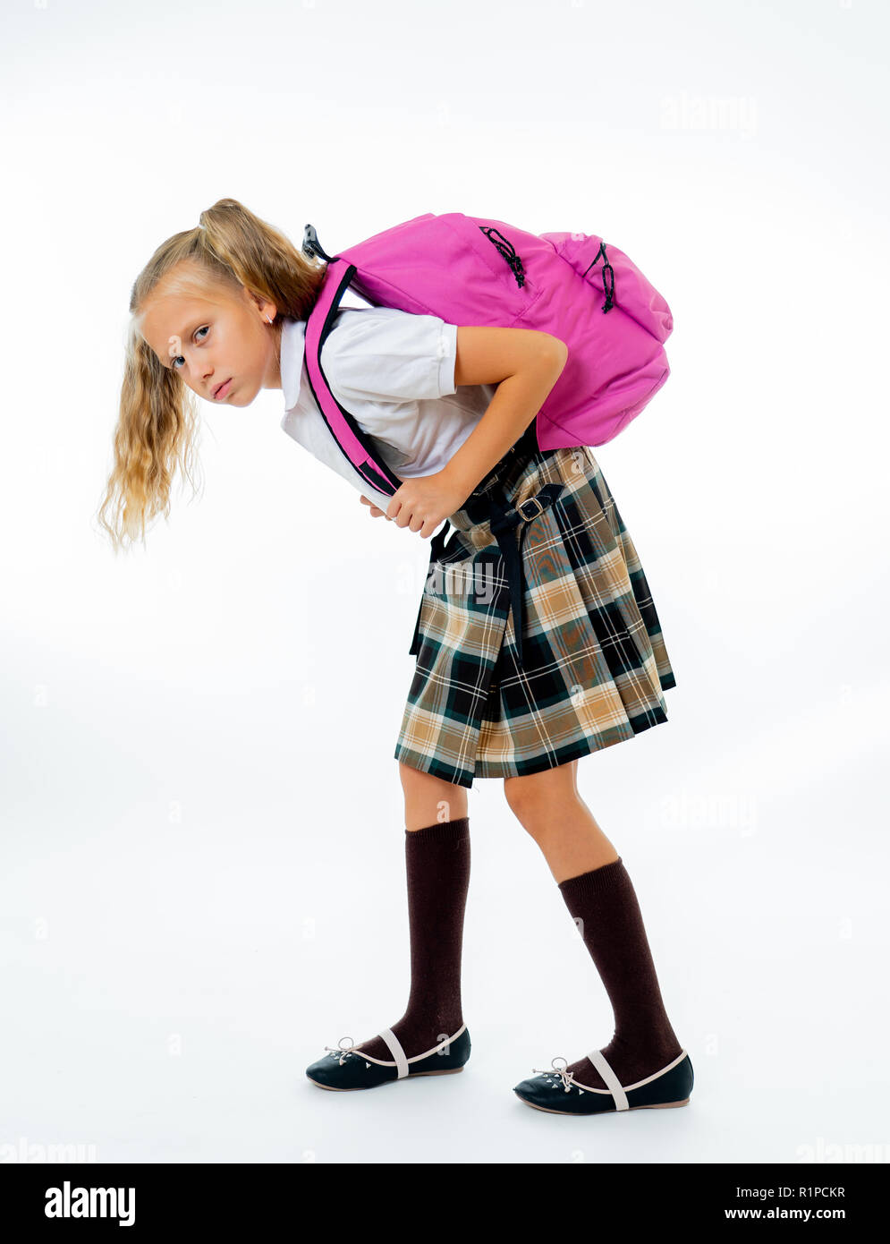 Young tired and sad cute school girl standing with a big heavy school