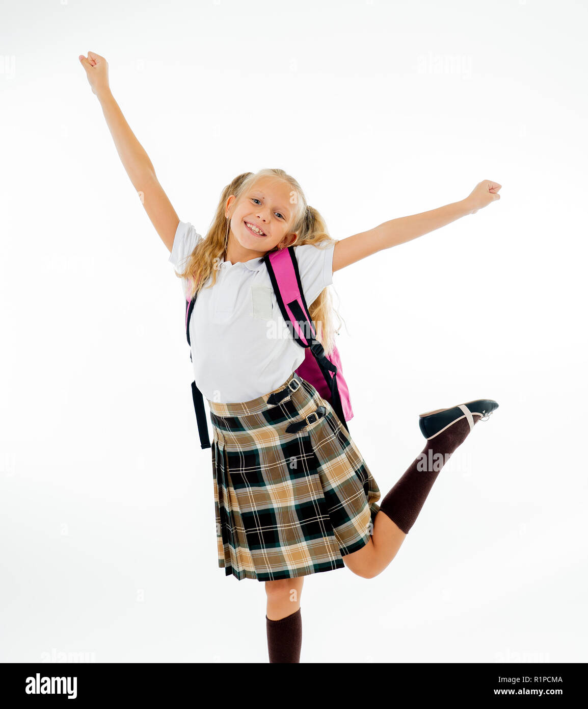 Adorable beautiful little schoolgirl with big pink schoolbag feeling excited and happy being back to school isolated on white background in end of the Stock Photo