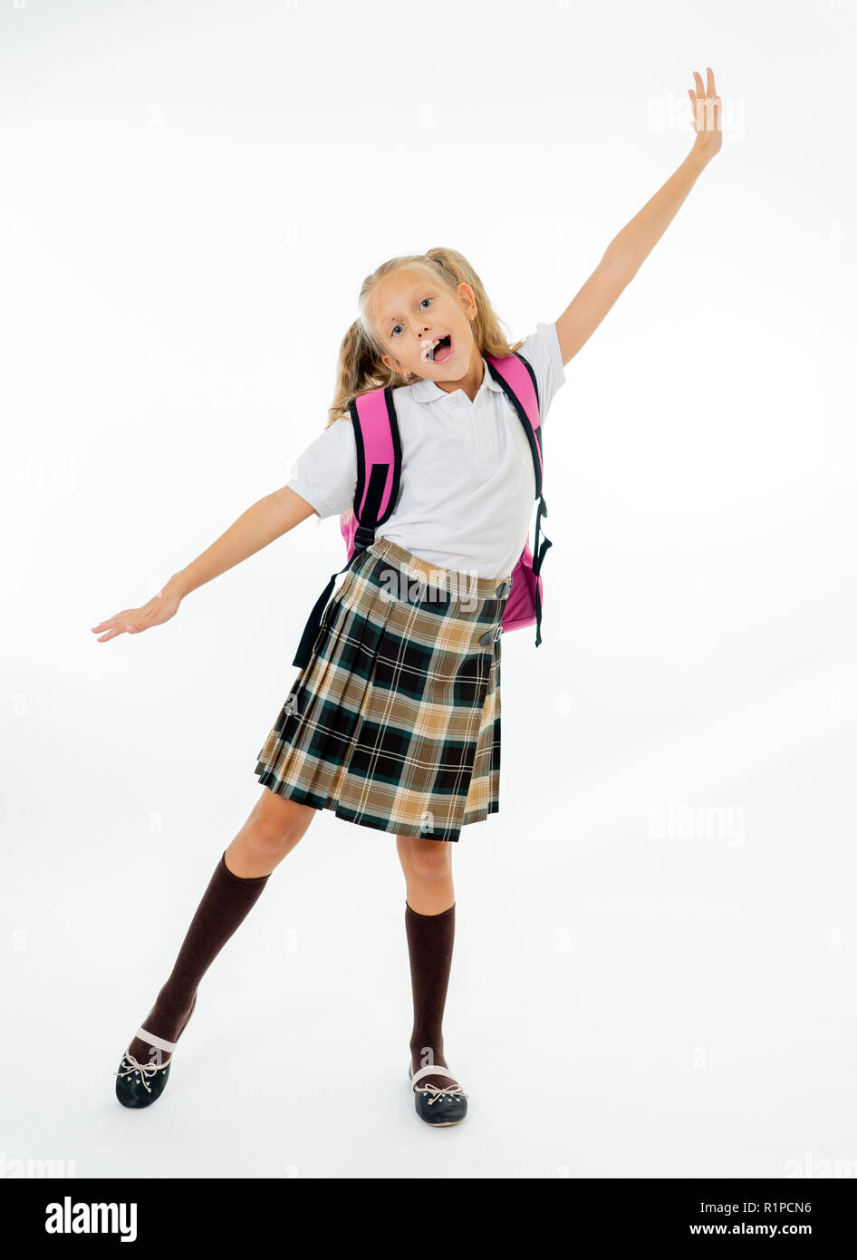 Adorable beautiful little schoolgirl with big pink schoolbag feeling excited and happy being back to school isolated on white background in end of the Stock Photo