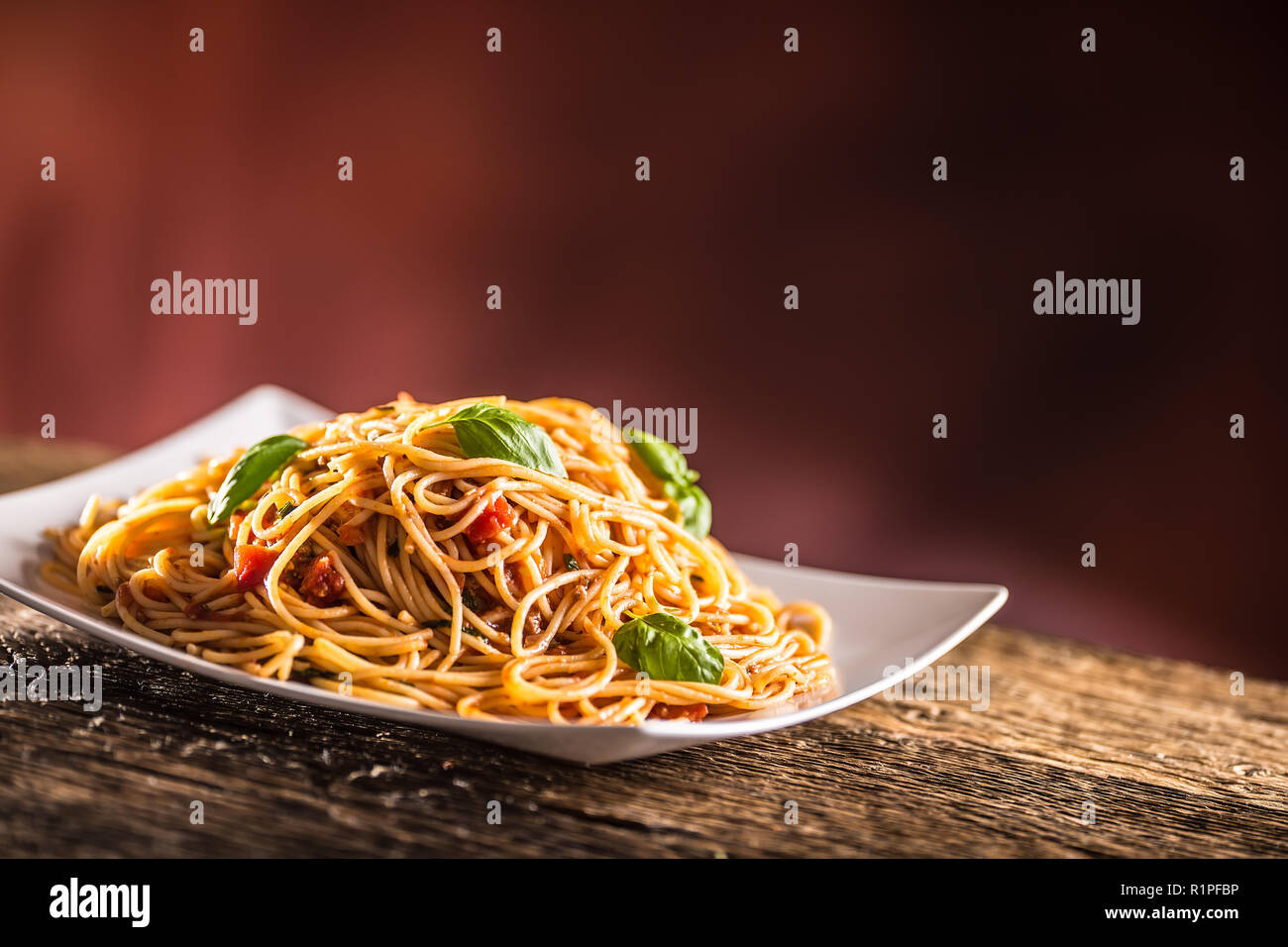 Italian pasta spaghetti with tomato sauce basil and parmesan cheese in white plate. Stock Photo