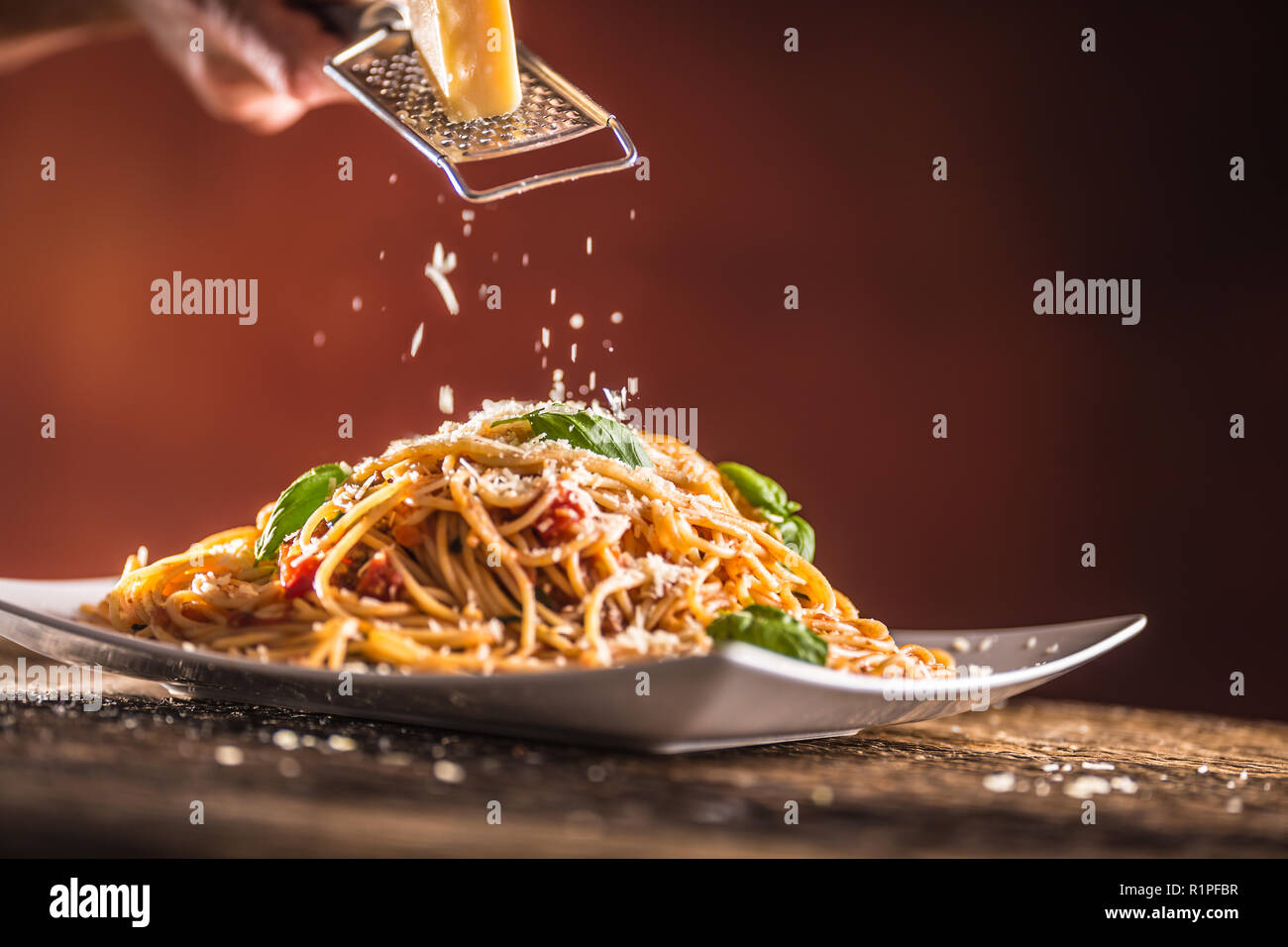 Italian pasta spaghetti with tomato sauce basil and parmesan cheese in white plate. Stock Photo