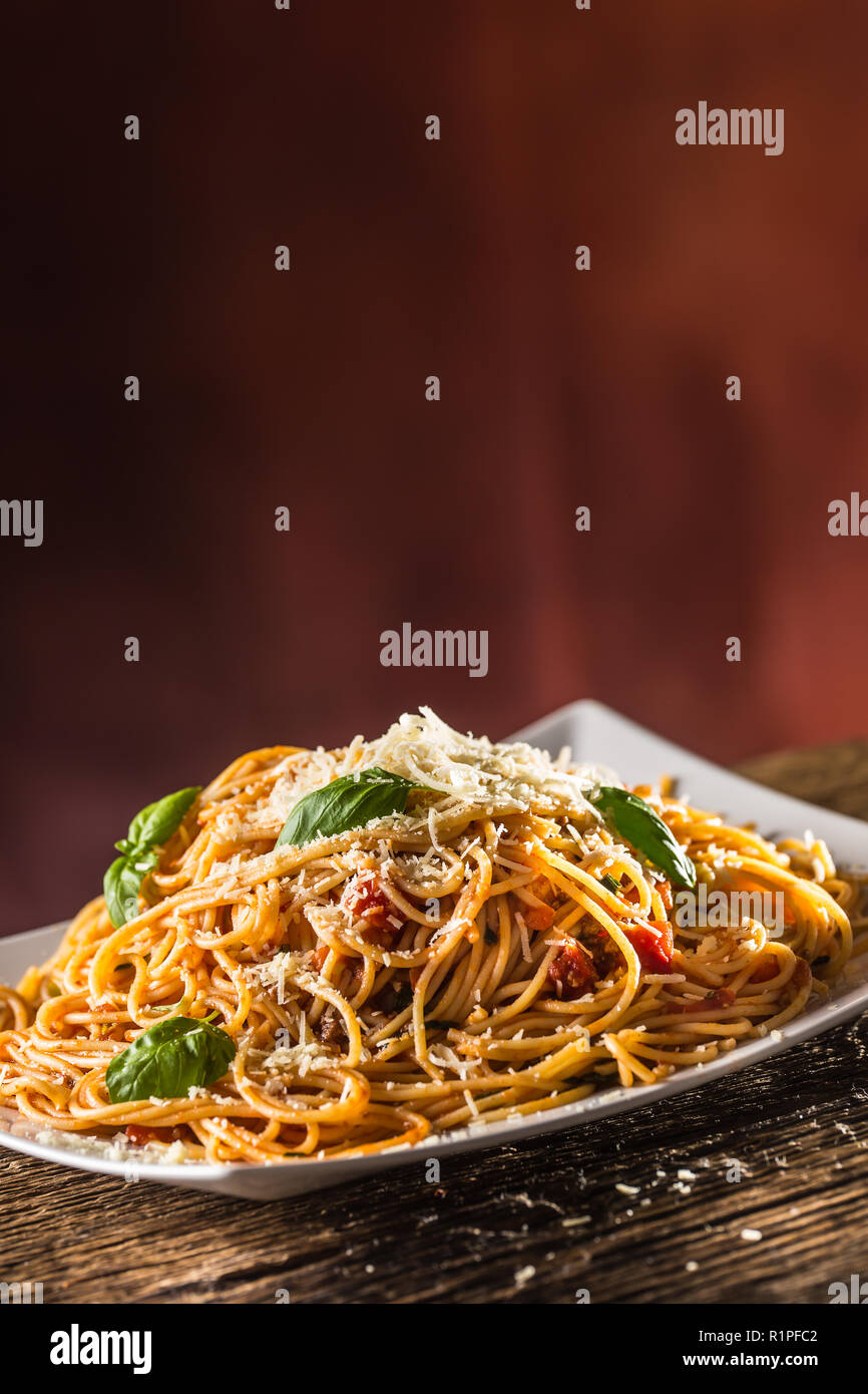 Italian pasta spaghetti with tomato sauce basil and parmesan cheese in white plate. Stock Photo