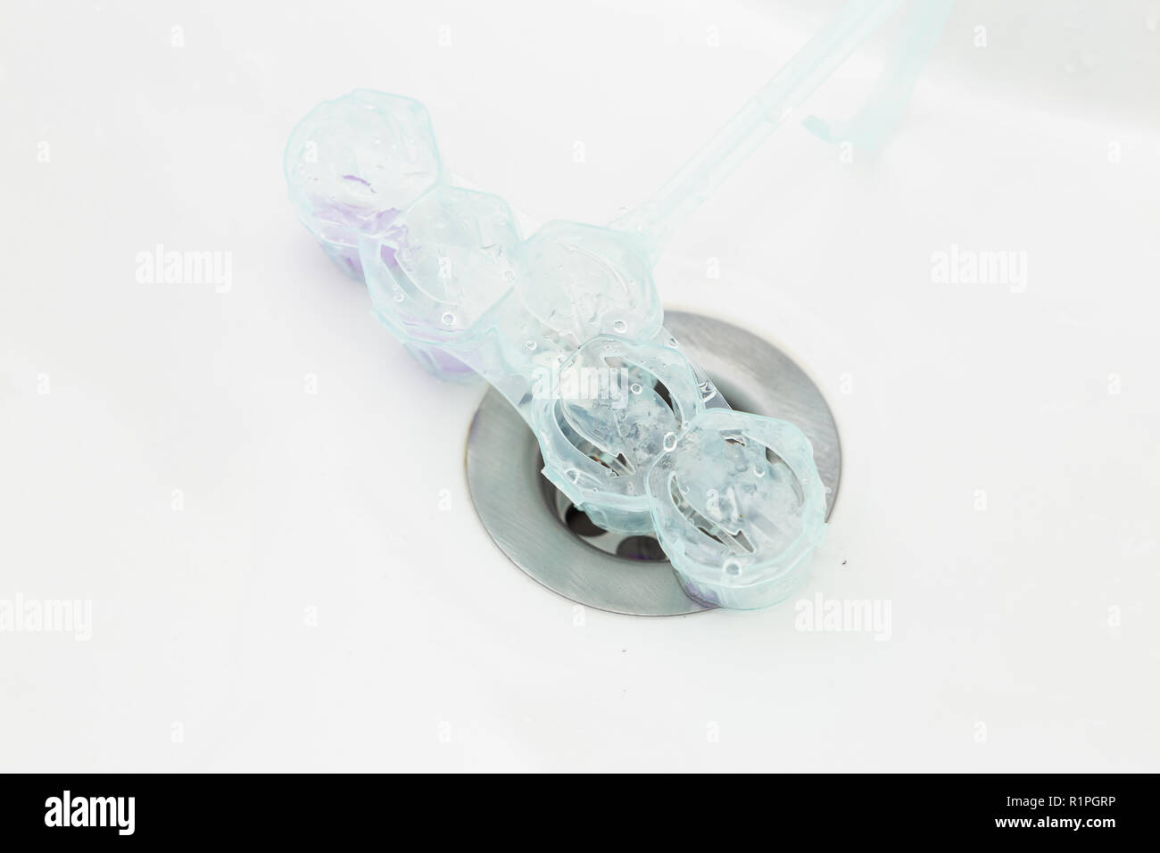 Empty plastic toilet freshener on metallic sink drain Stock Photo Alamy
