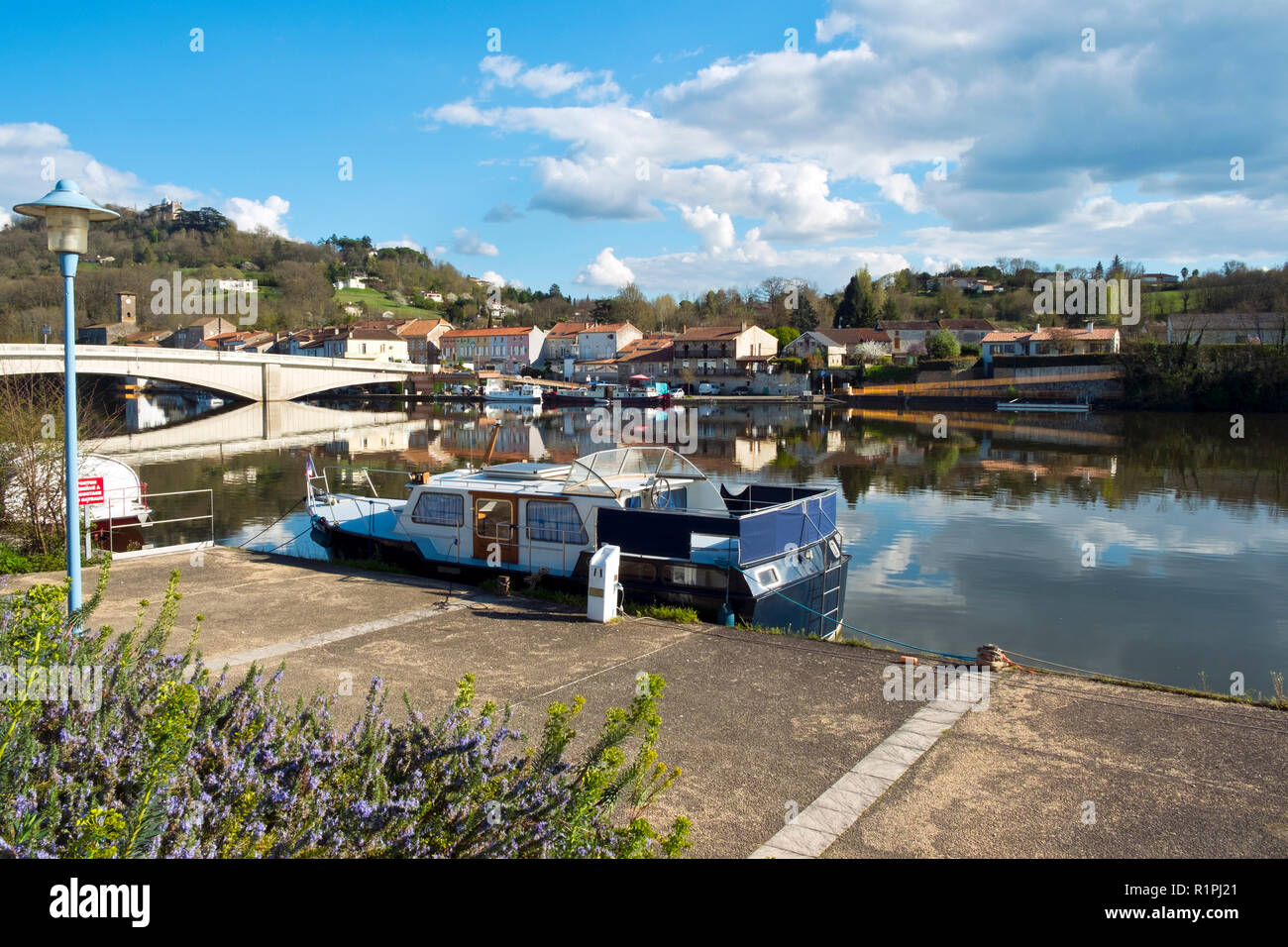 28th March 2017 -  Saint- Sylvestre-sur-Lot, France: Boats moored in spring morning sunshine on the placid River Lot at Saint- Sylvestre-sur-Lot, Lot-et-Garonne, France. Across the river is Port de Penne, the ancient river port for Penne d'Agenais town. Stock Photo