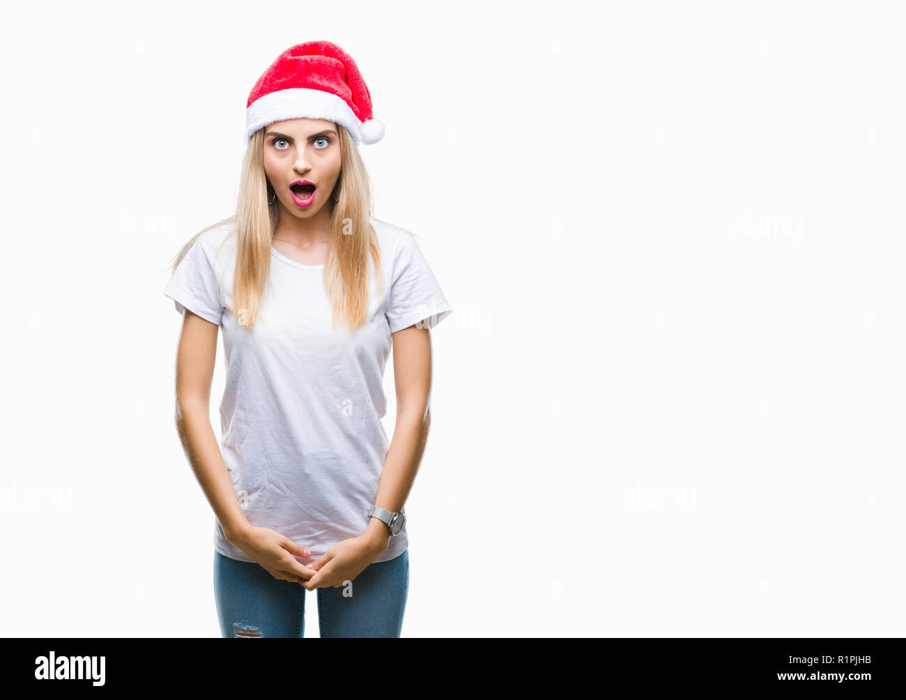 Young beautiful blonde woman christmas hat over isolated background afraid and shocked with surprise expression, fear and excited face. Stock Photo