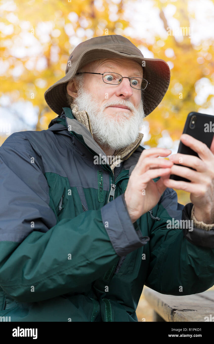 Senior man outdoors using a smartphone Stock Photo