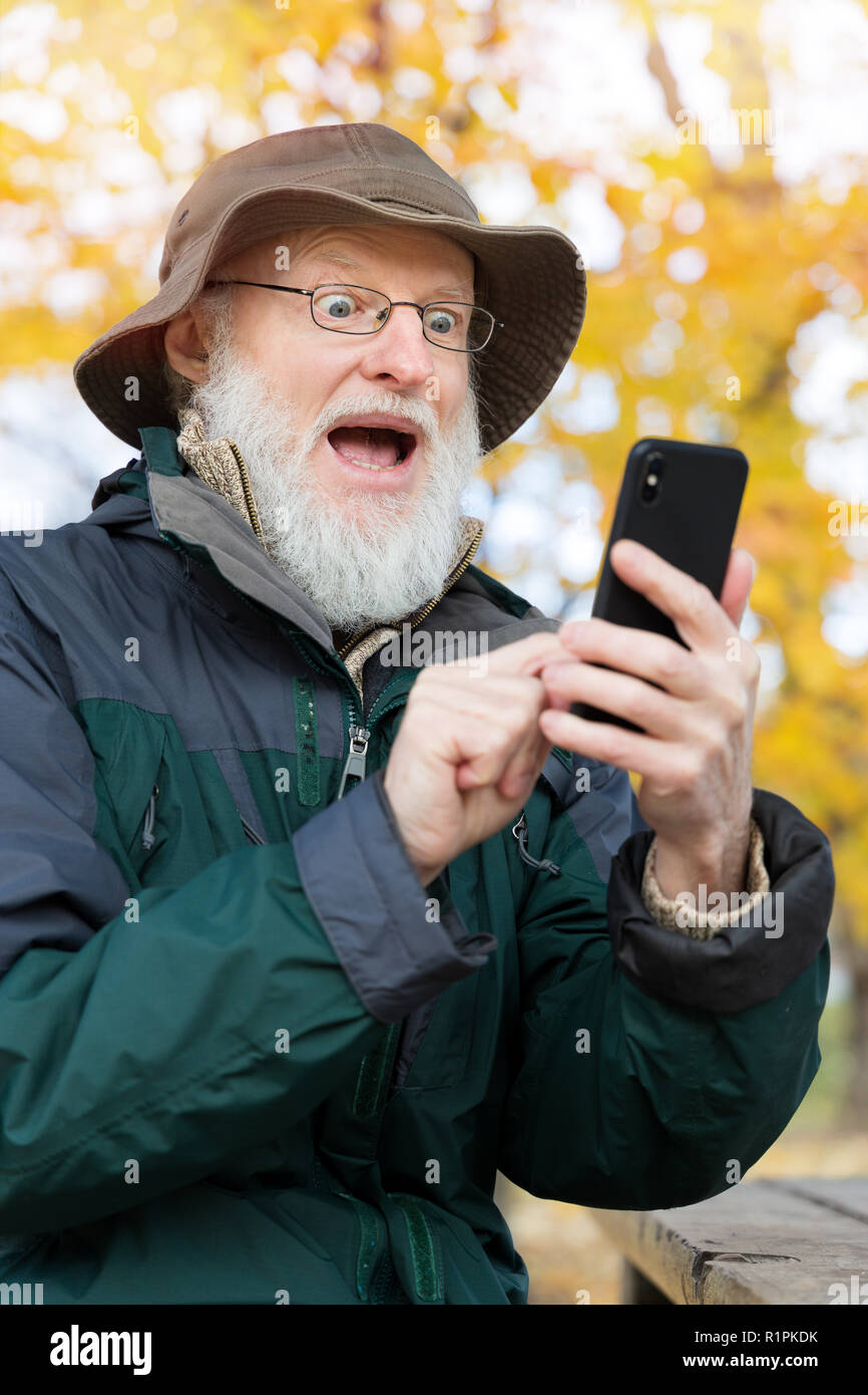 Senior man outdoors using a smartphone Stock Photo