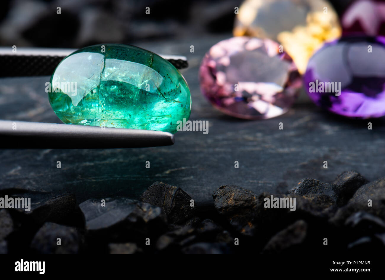 The emerald gemstone jewelry photo with black stones and dark lighting  Stock Photo - Alamy