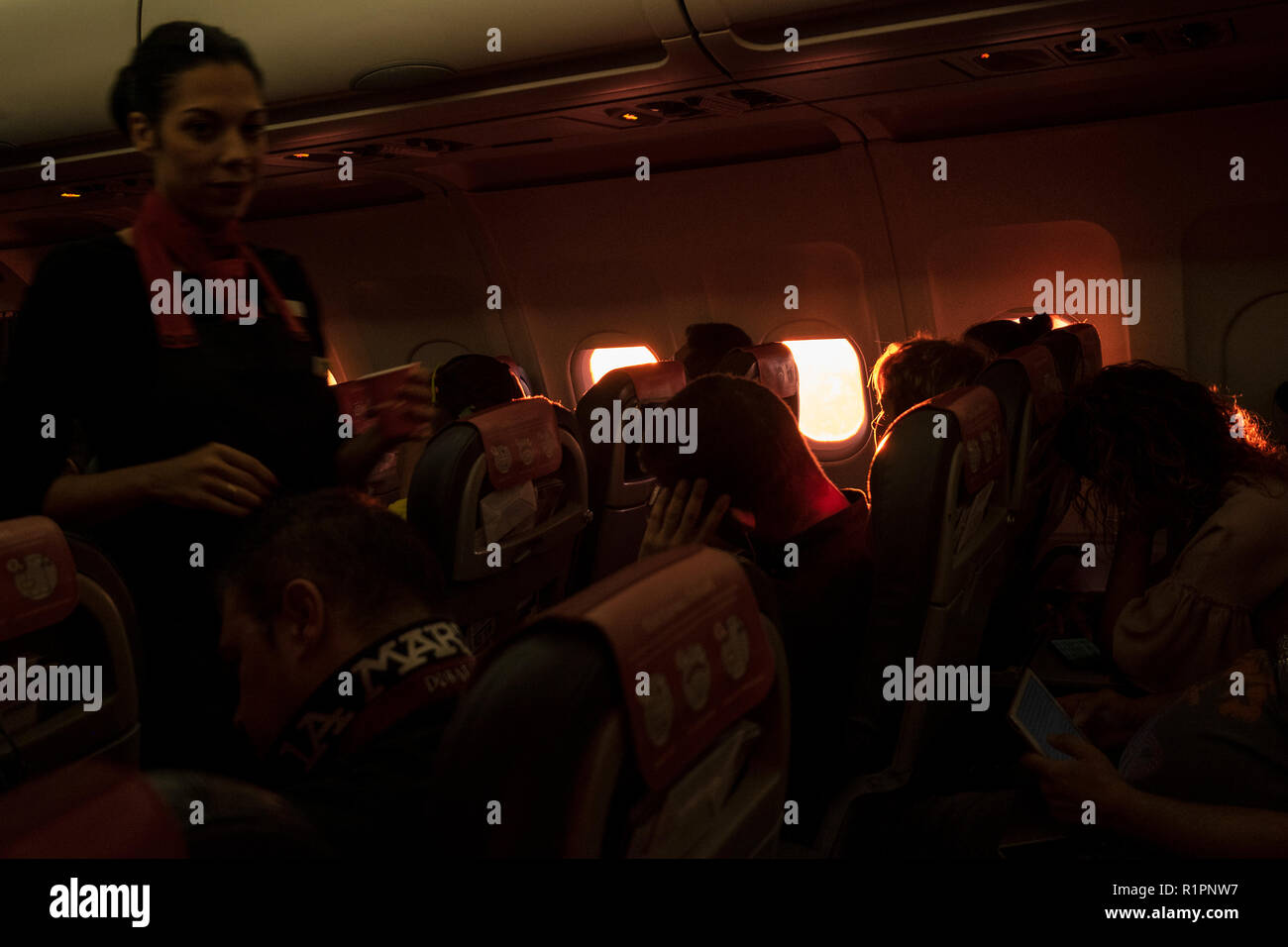 Early morning flight cabin interior lit by dawn sunlight on Iberia Express plane Stock Photo
