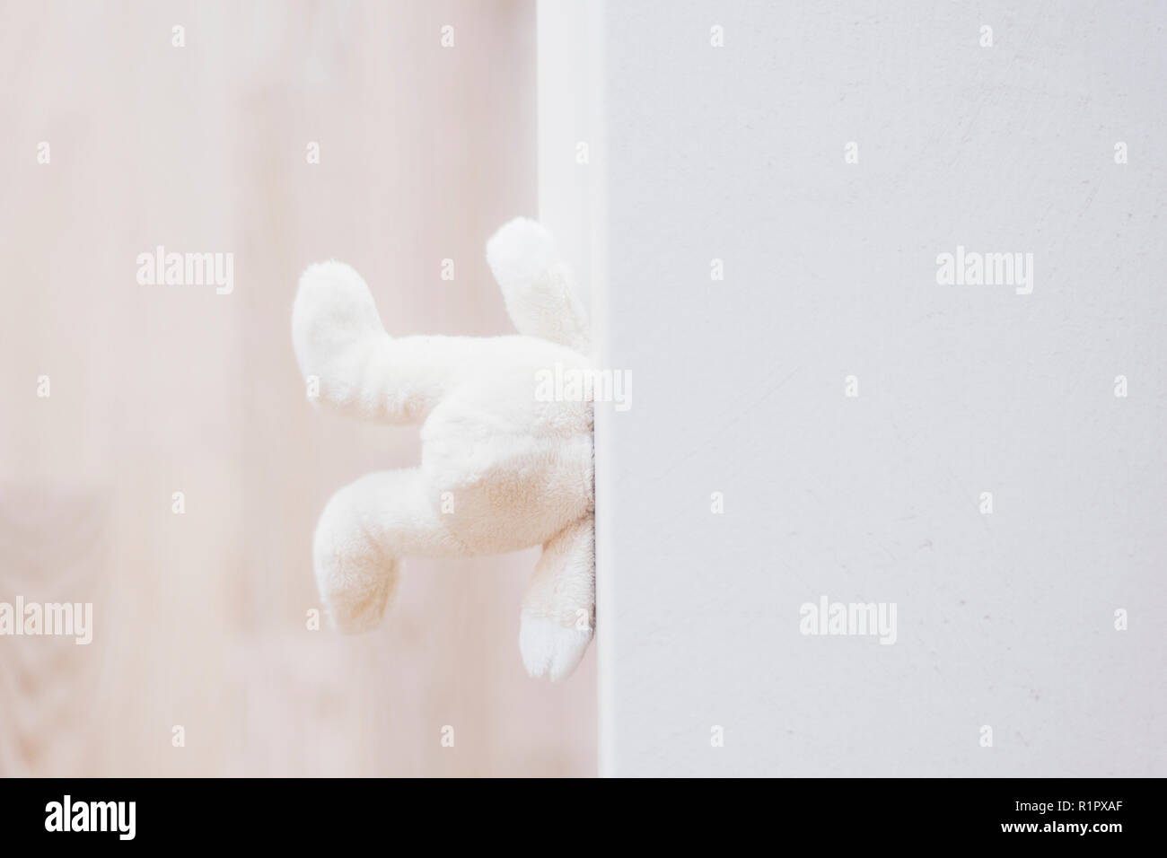 closeup of teddy bear on white chest of drawers background. Bad childhood Stock Photo