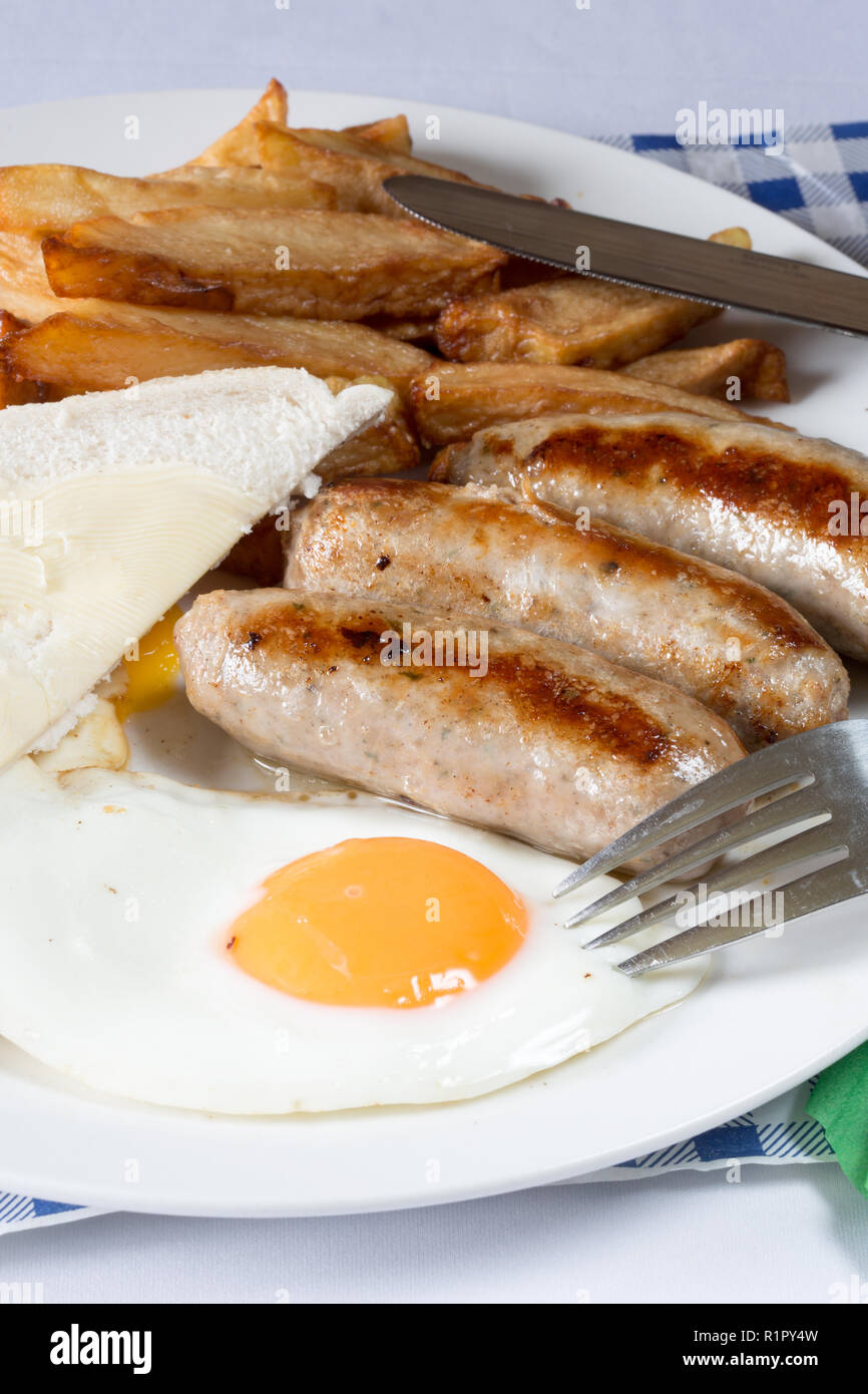 Classic British supper of Sausage, egg and chips with white sliced