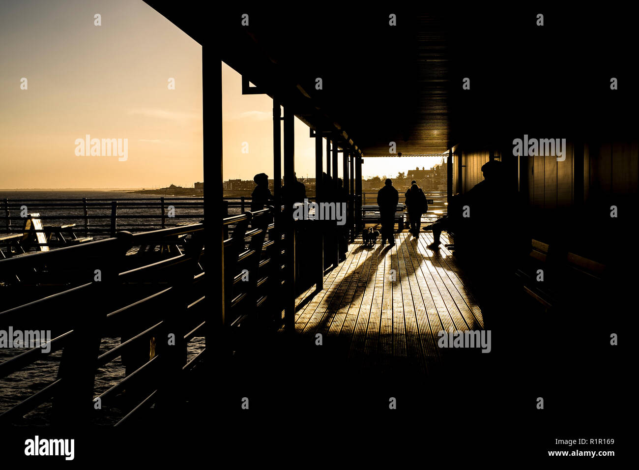 People on the newly refurbished pier in Felixstowe, Suffolk, close to sunset on a winters day Stock Photo