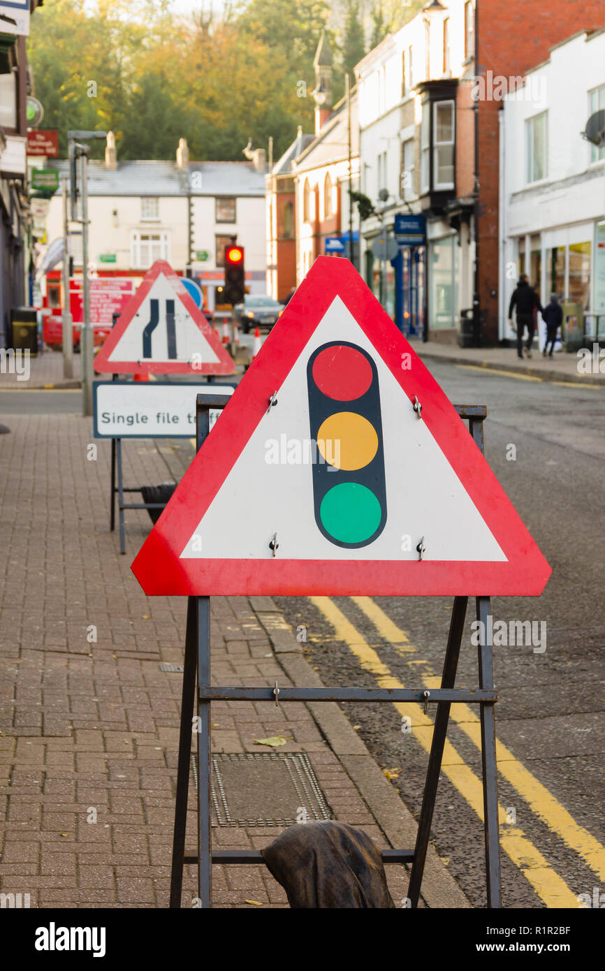 Temporary road works signs and traffic lights controlling vehicle access during highway repairs in Llangollen Wales Stock Photo