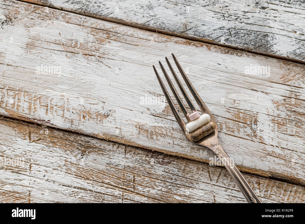Tablets with silver fork on an old wooden table with white paint Stock Photo