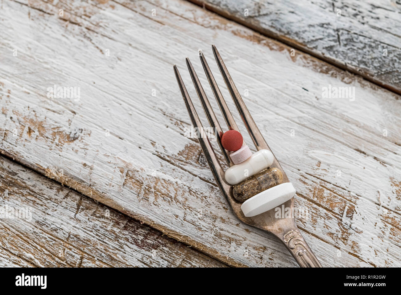 Tablets with silver fork on an old wooden table with white paint Stock Photo