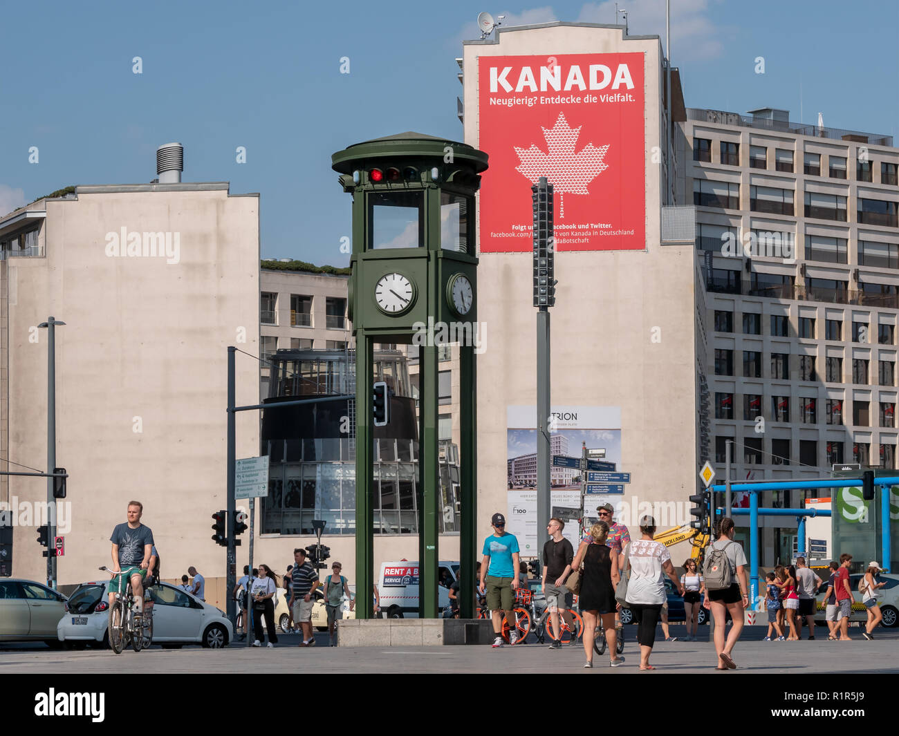 BERLIN, GERMANY - AUGUST 4, 2018: People And Traffic At The Clock At Famous Potsdamer Platz In Berlin In Summer, Canadian Embassy In The Background Stock Photo