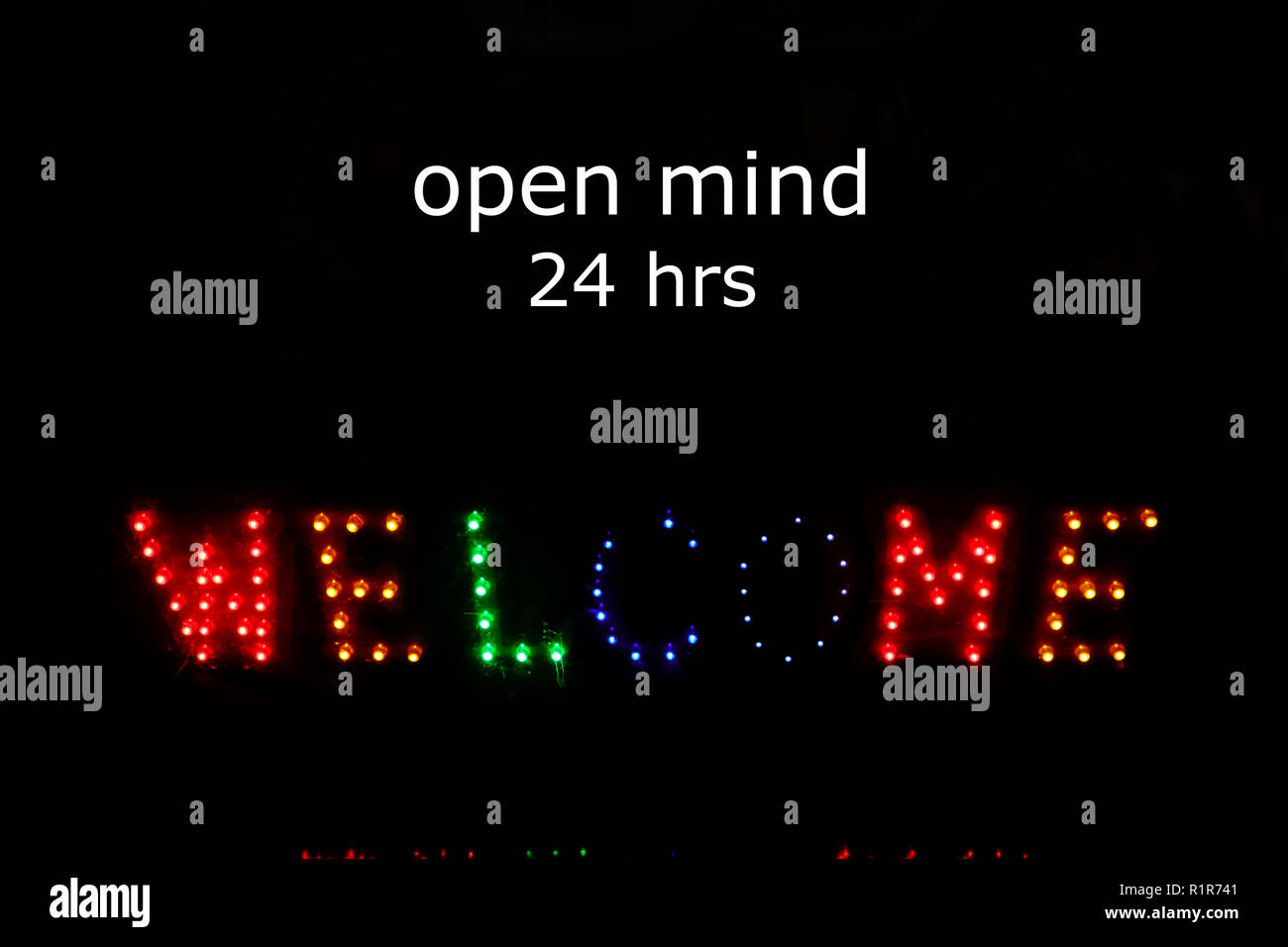 welcome sign made from LED light on dark background and words read open mind 24 hrs above it, open mind concept Stock Photo