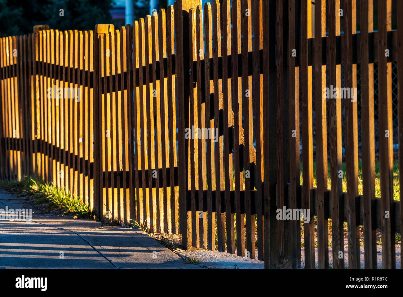 Late day sunlight creates patterns on wooden picket fence; 325 D Street;   Salida; Colorado; USA Stock Photo