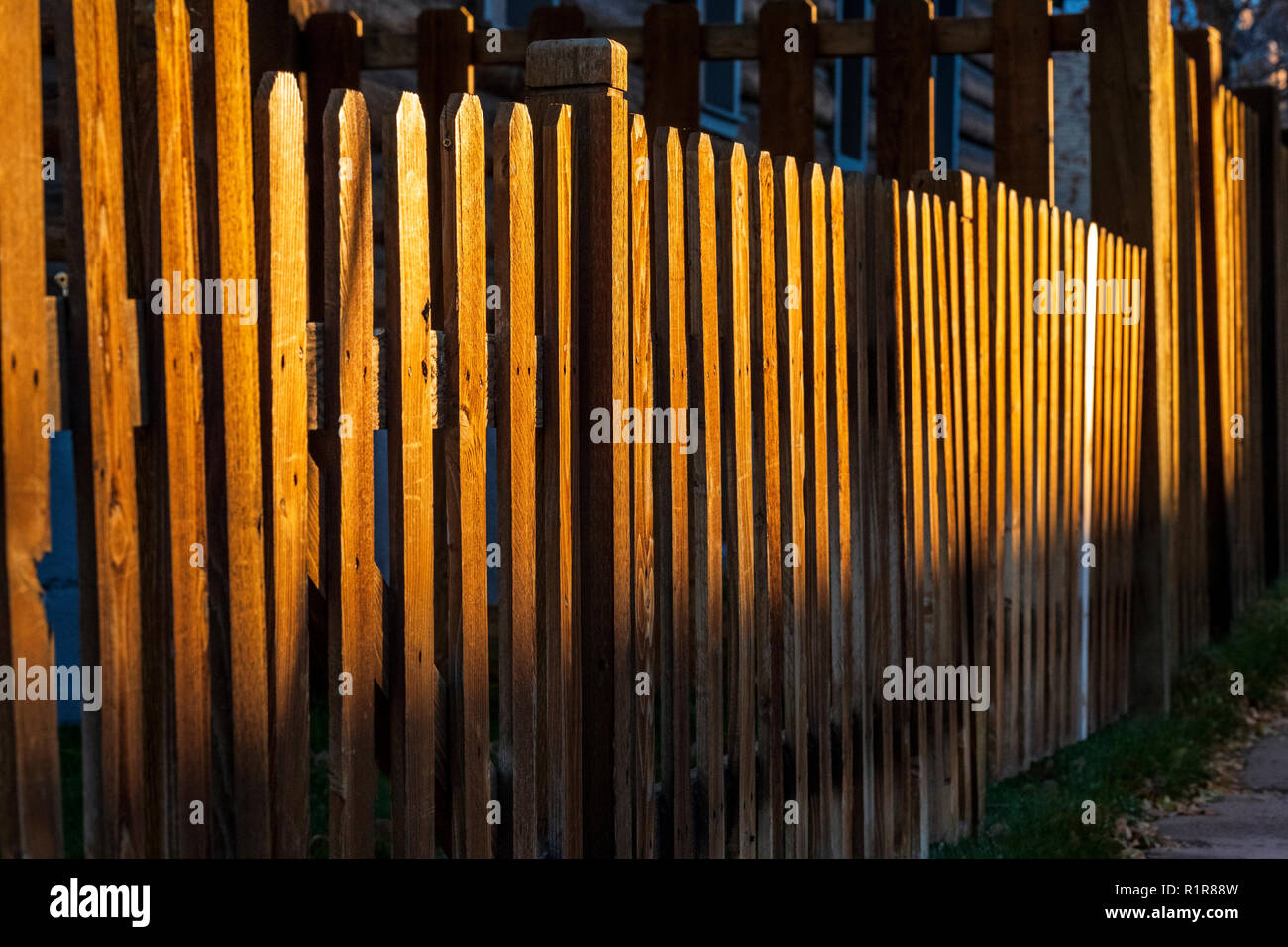 Late day sunlight creates patterns on wooden picket fence; 325 D Street;   Salida; Colorado; USA Stock Photo