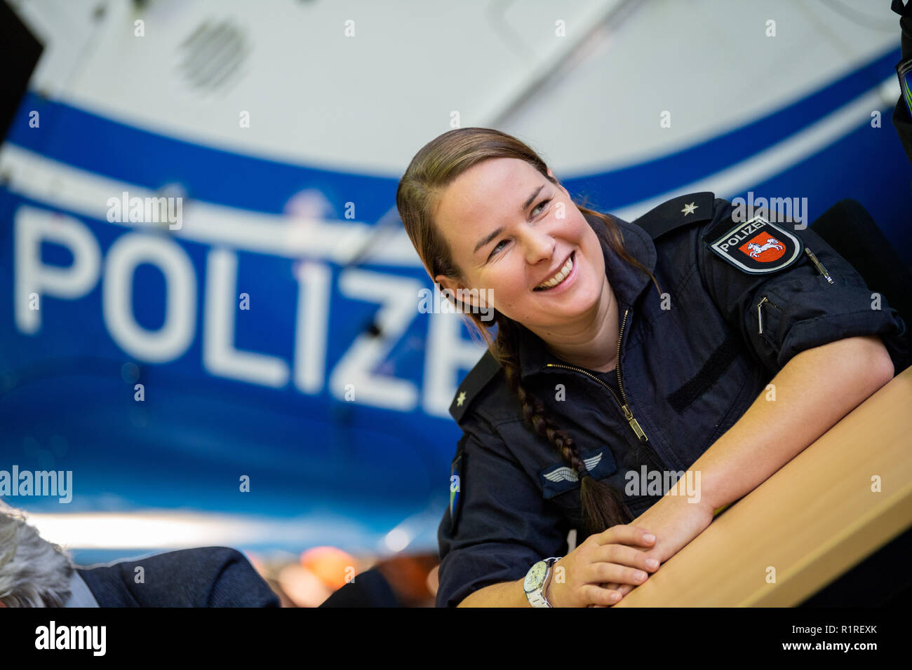 Rastede, Germany. 14th Nov, 2018. Kirsten Böning, first female helicopter pilot of the police of Lower Saxony, sits in front of a police helicopter during a press conference. Credit: Mohssen Assanimoghaddam/dpa/Alamy Live News Stock Photo