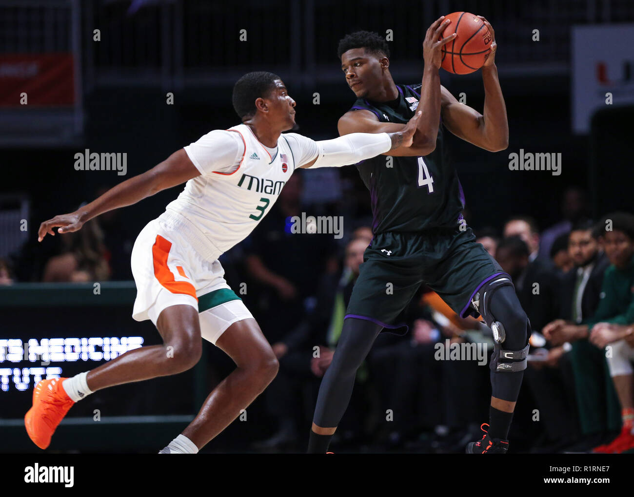 Coral Gables, Florida, USA. 13th Nov, 2018. Stephen F. Austin Lumberjacks forward Davonte Fitzgerald (4) looks to pass the ball defended by Miami Hurricanes guard Anthony Lawrence II (3) during the first half of the NCAA mens basketball game between the Stephen F. Austin Lumberjacks and the University of Miami Hurricanes at the Watsco Center in Coral Gables, Florida. Mario Houben/CSM/Alamy Live News Stock Photo
