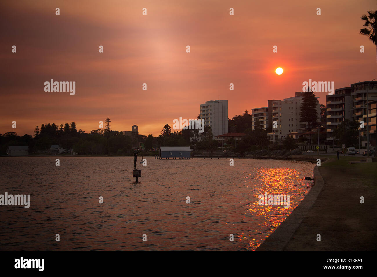 Sunset over Matilda Bay, Perth, Australia. Colourful sky with orange sun casts glow over the River Swan Stock Photo