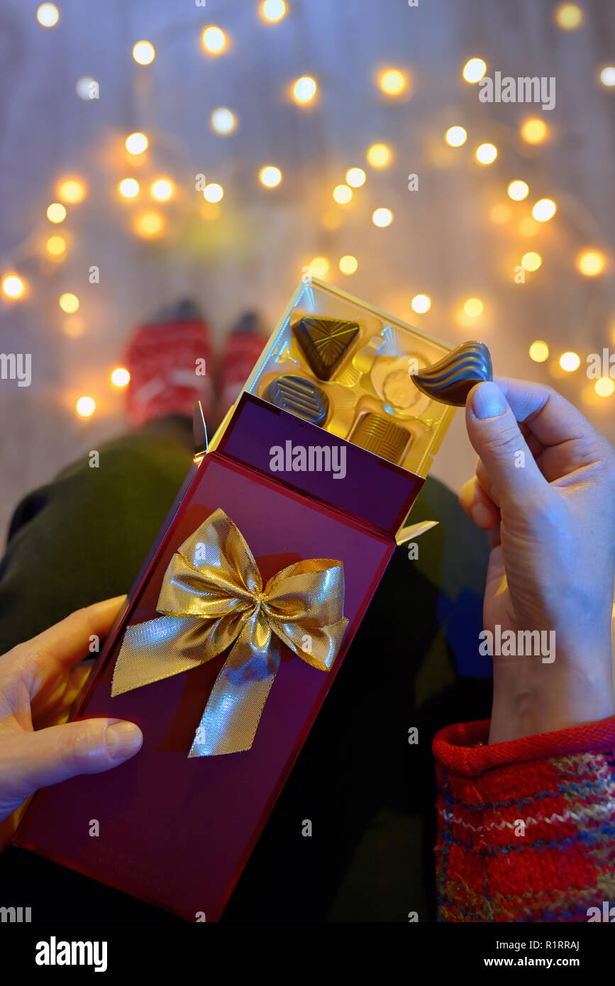 Woman Holding Chocolate Present Next To Christmas Lights Stock Photo ...