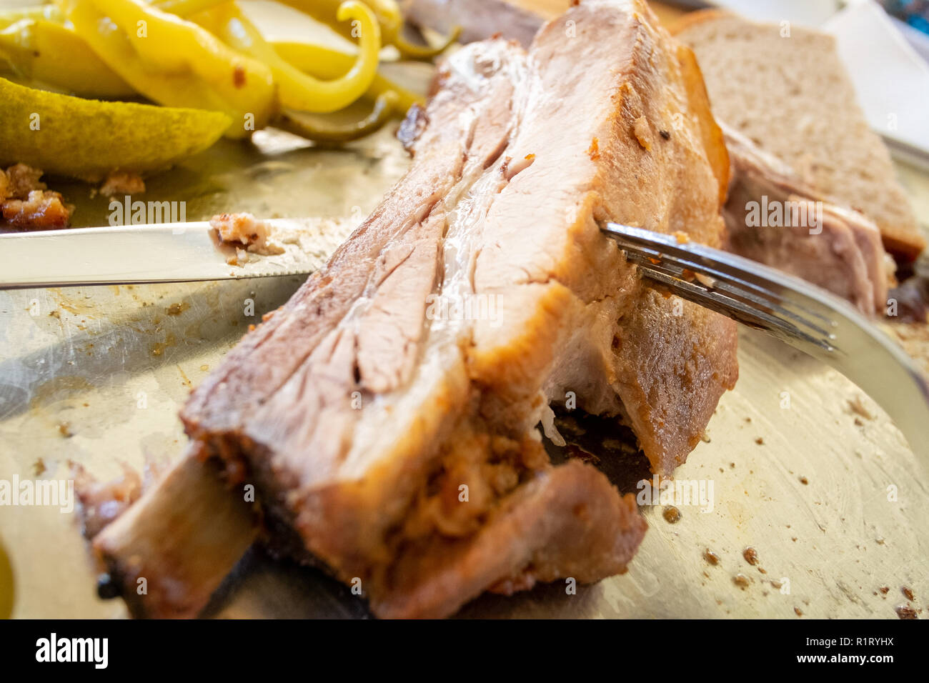 Fresh pork ribs close up food photography, large rib with lots of meat and a fork for scale served at a Czech Restaurant Stock Photo