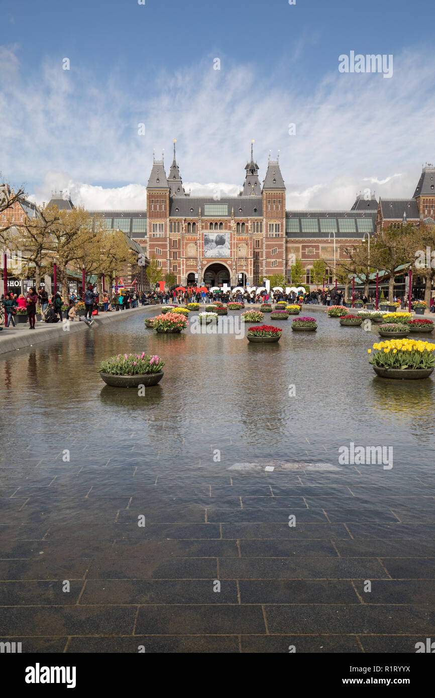 AMSTERDAM, NETHERLANDS - APRIL 22 2017: Rijksmuseum National Museum with I Amsterdam sign and tulips in the reflecting pool. Amsterdam, Netherlands Stock Photo