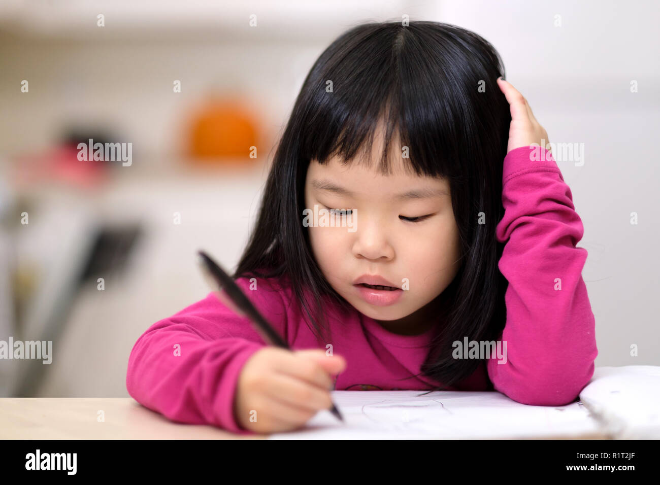 Young little Asian girl learning to write Stock Photo