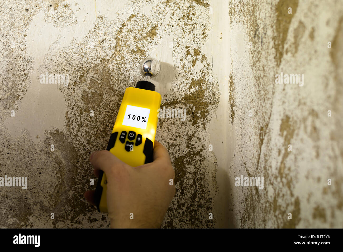 Person is measuring the humidity in a wet wall Stock Photo