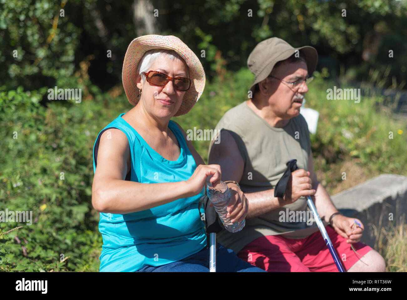 Senior couple on hike resting and drinking water Stock Photo