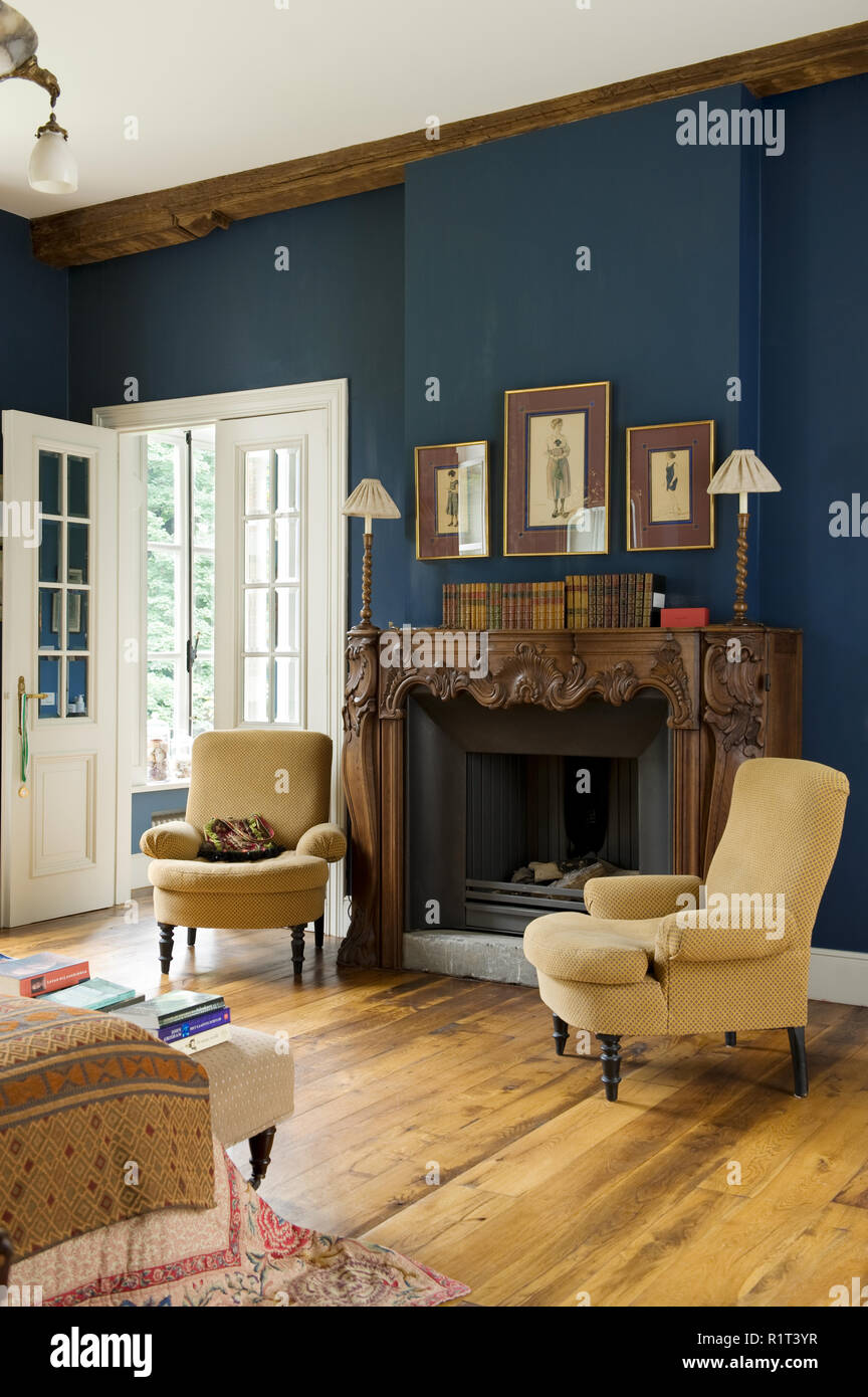 Armchairs around fireplace in bedroom Stock Photo Alamy