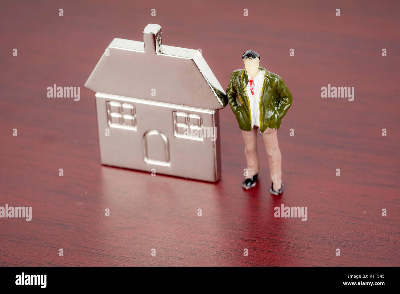 Miniature figure and metal house replica for property investment concept Stock Photo
