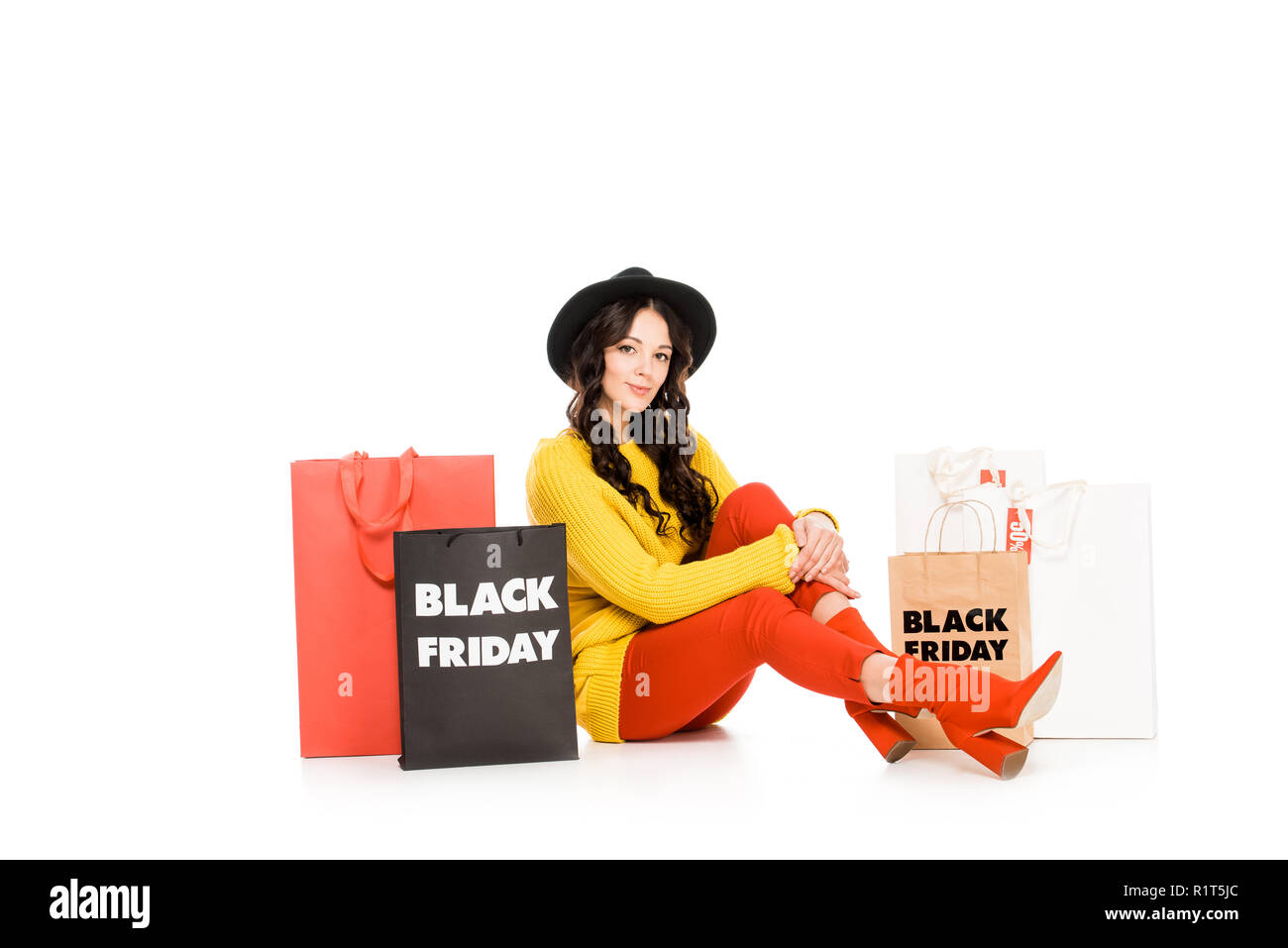 beautiful female customer sitting at shopping bags on black friday sale, isolated on white Stock Photo