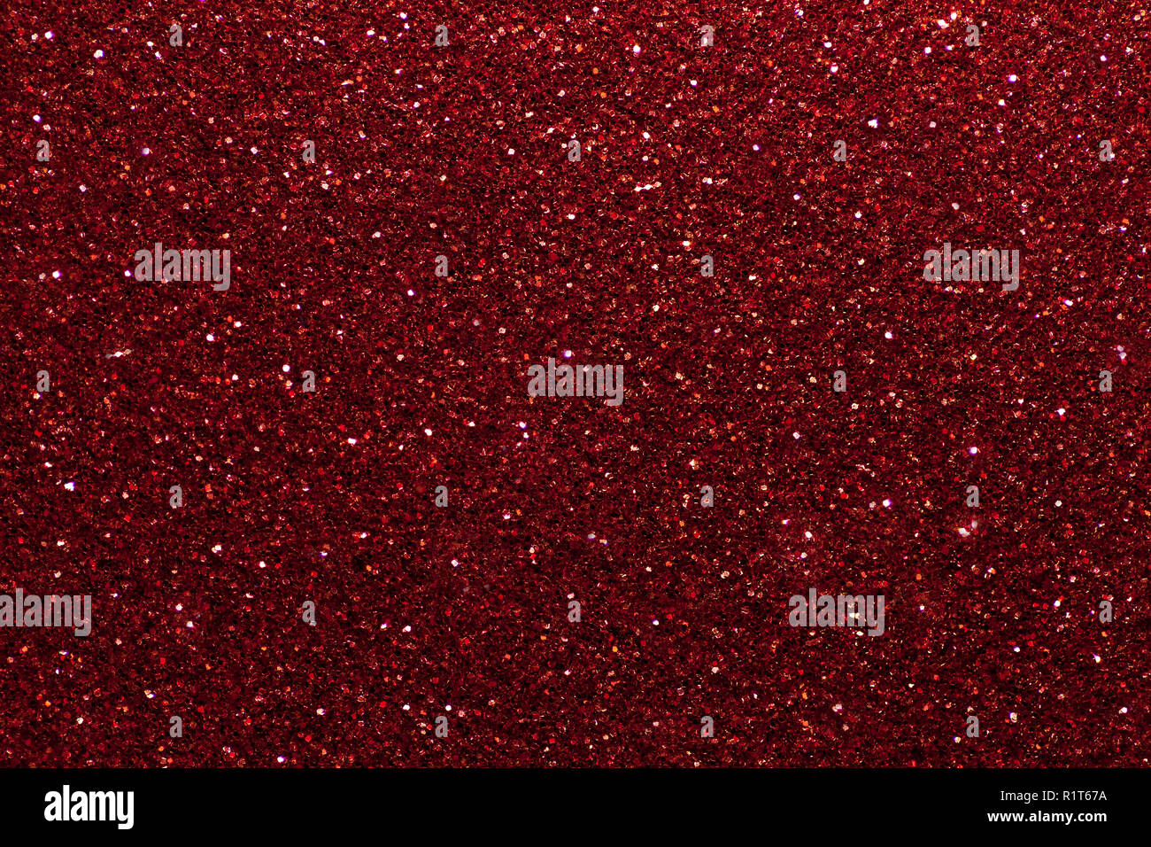 Dark red sparkling background from small sequins, closeup. Brilliant
