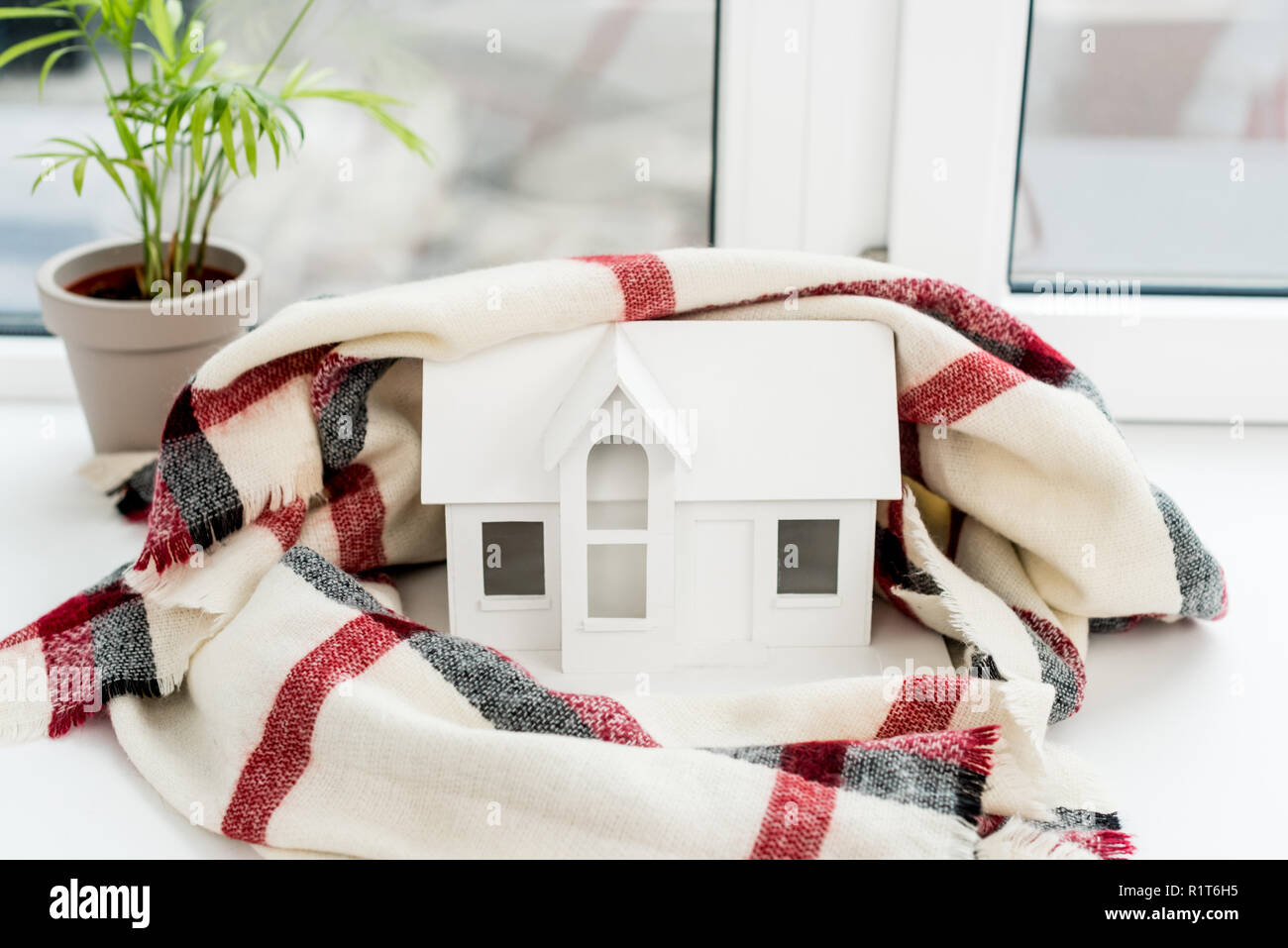 close-up shot of toy house model with plaid on windowsill Stock Photo